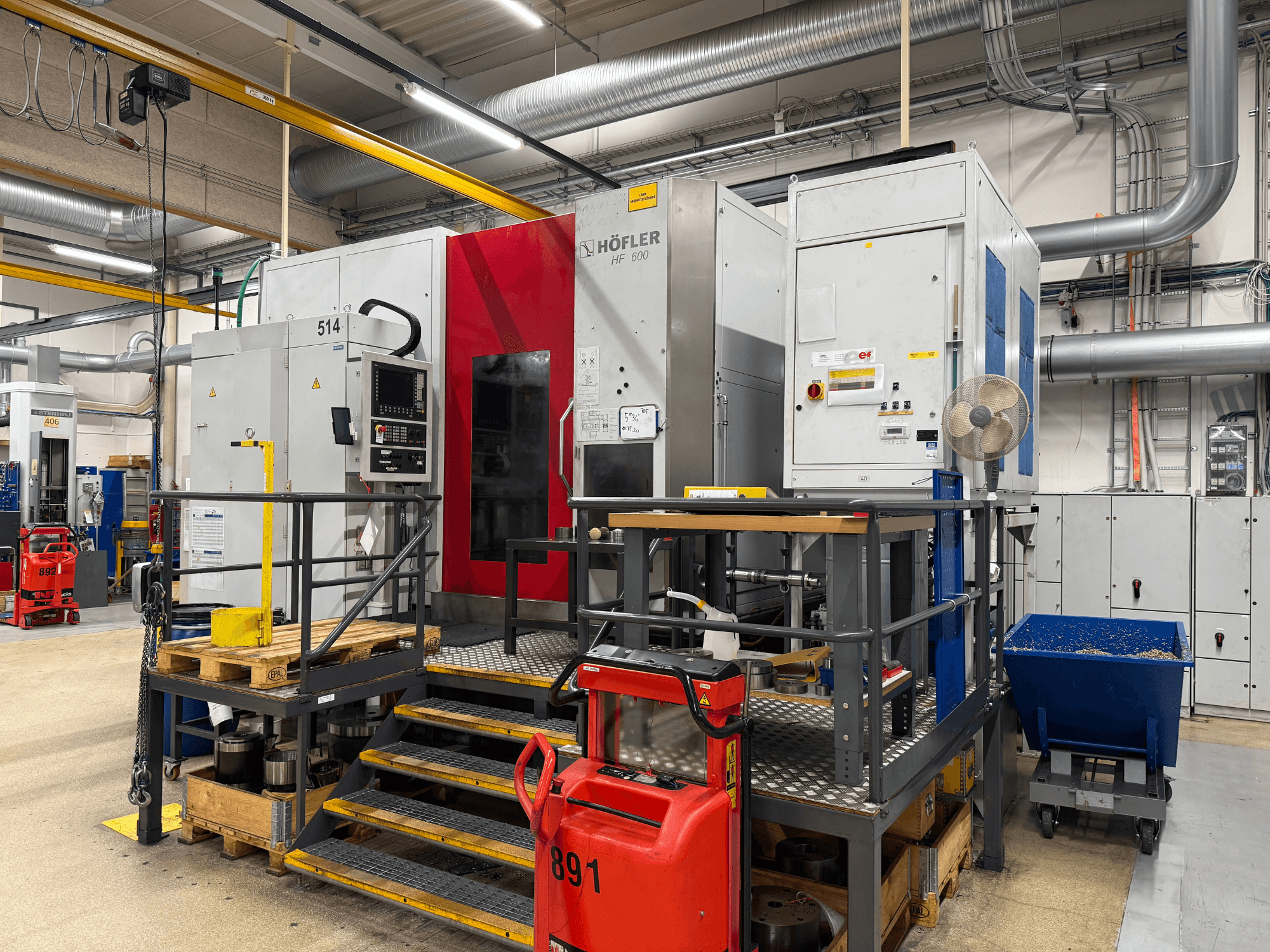 Станок HOFLER HF 600, вид сбоку, видна панель управления, желтый барьер безопасности и окружающая обстановка в мастерской.
