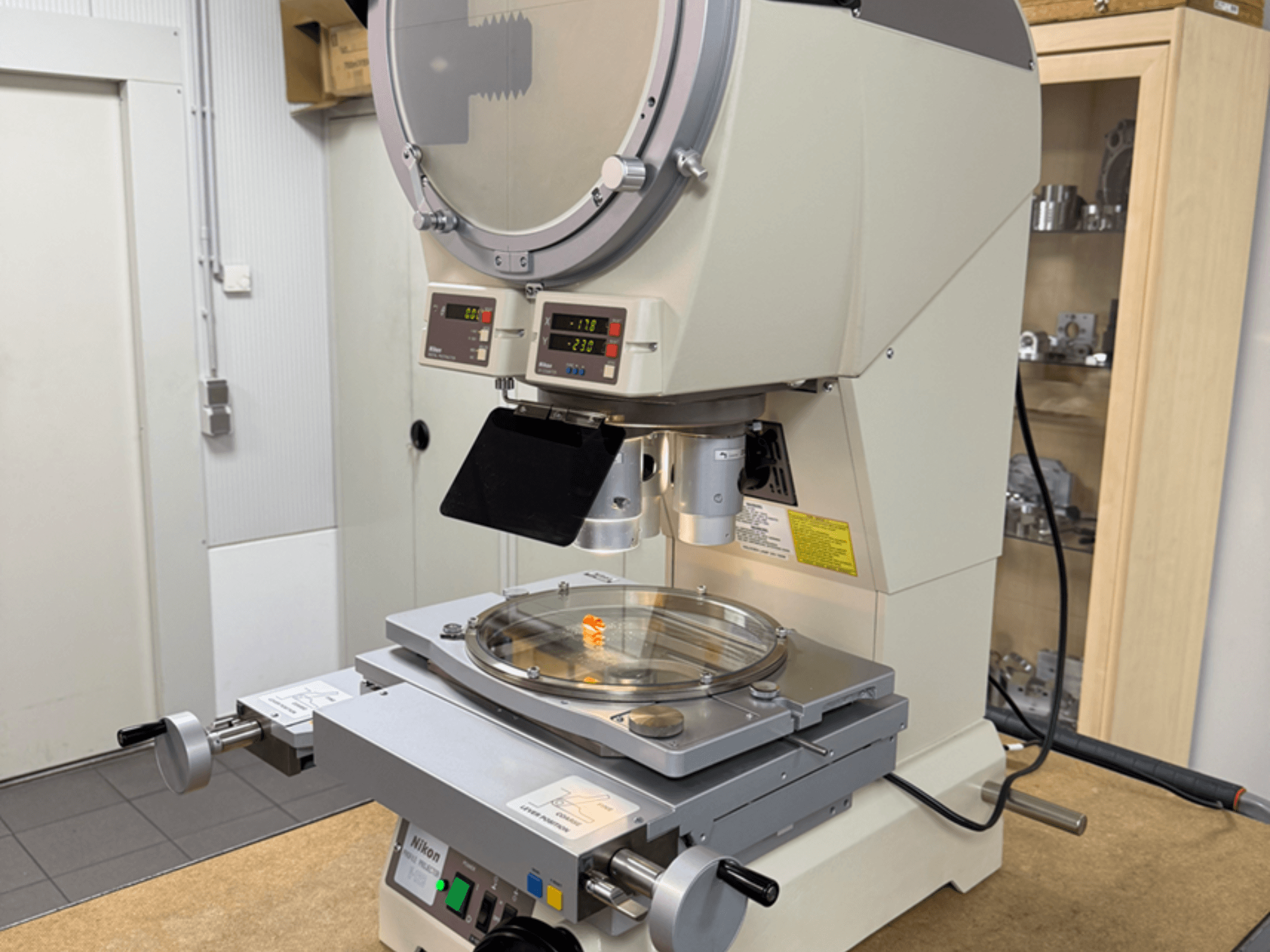 Модель микроскопа Nikon с видом спереди, оснащенная цифровыми дисплеями, регулируемым штативом и круглой стеклянной пластиной.