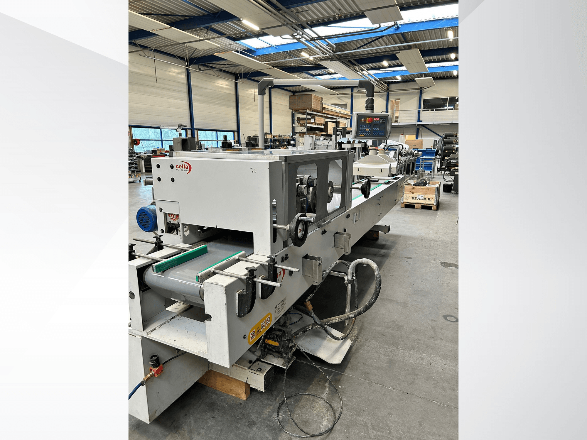 Вид спереди деревообрабатывающего станка CEFLA Smartparquet MRF-2VS/300 с панелью управления и конвейером с зелеными роликами.