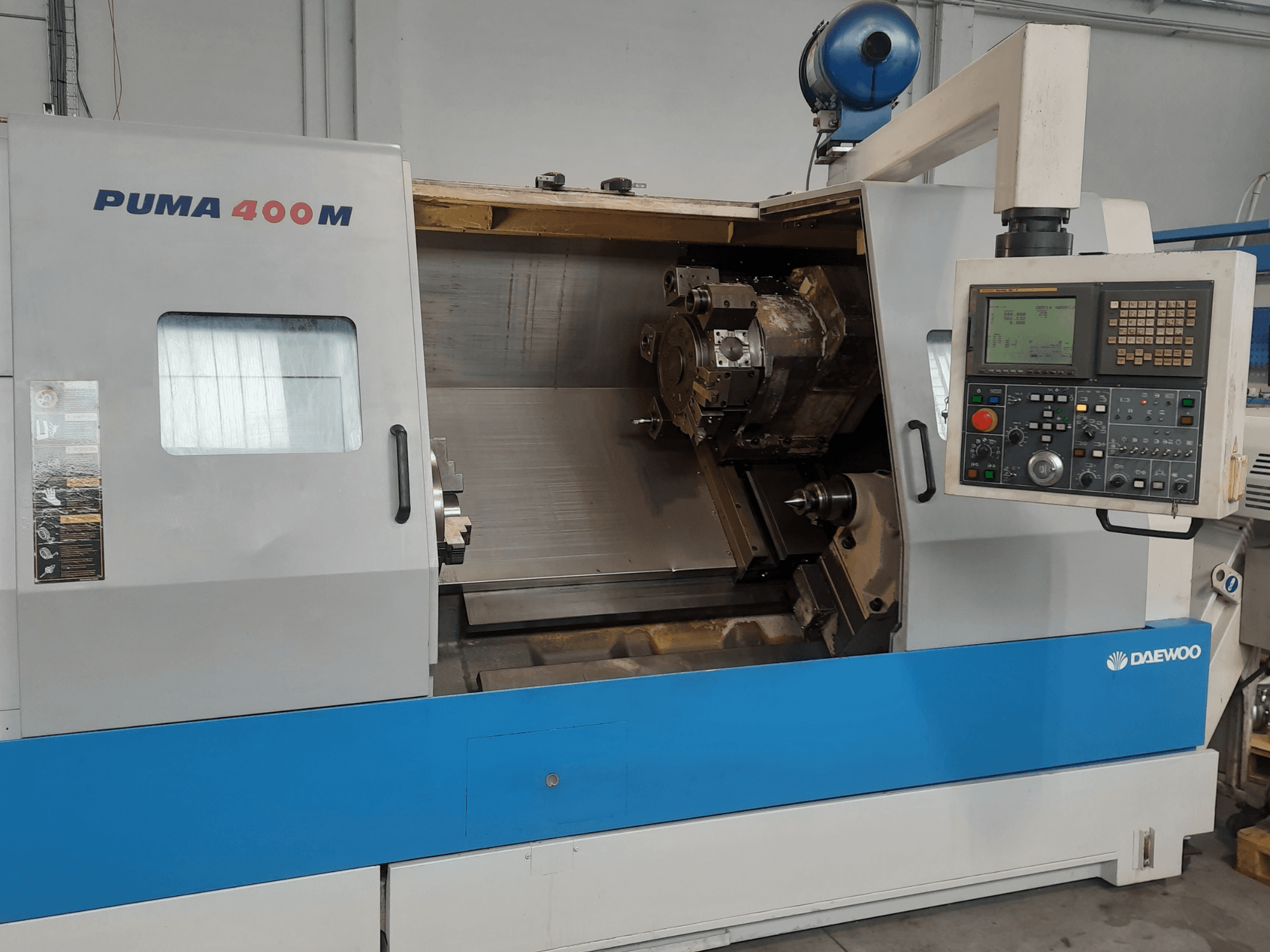 Вид спереди на горизонтальный токарный станок DAEWOO PUMA 400MB с изображением органов управления и режущего инструмента в рабочей камере.
