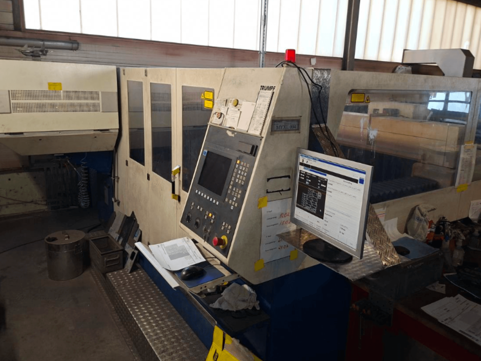 Станок для лазерной резки CO2 TRUMPF Trumatic L 4030, вид спереди с панелью управления и монитором, видны детали рабочего пространства.