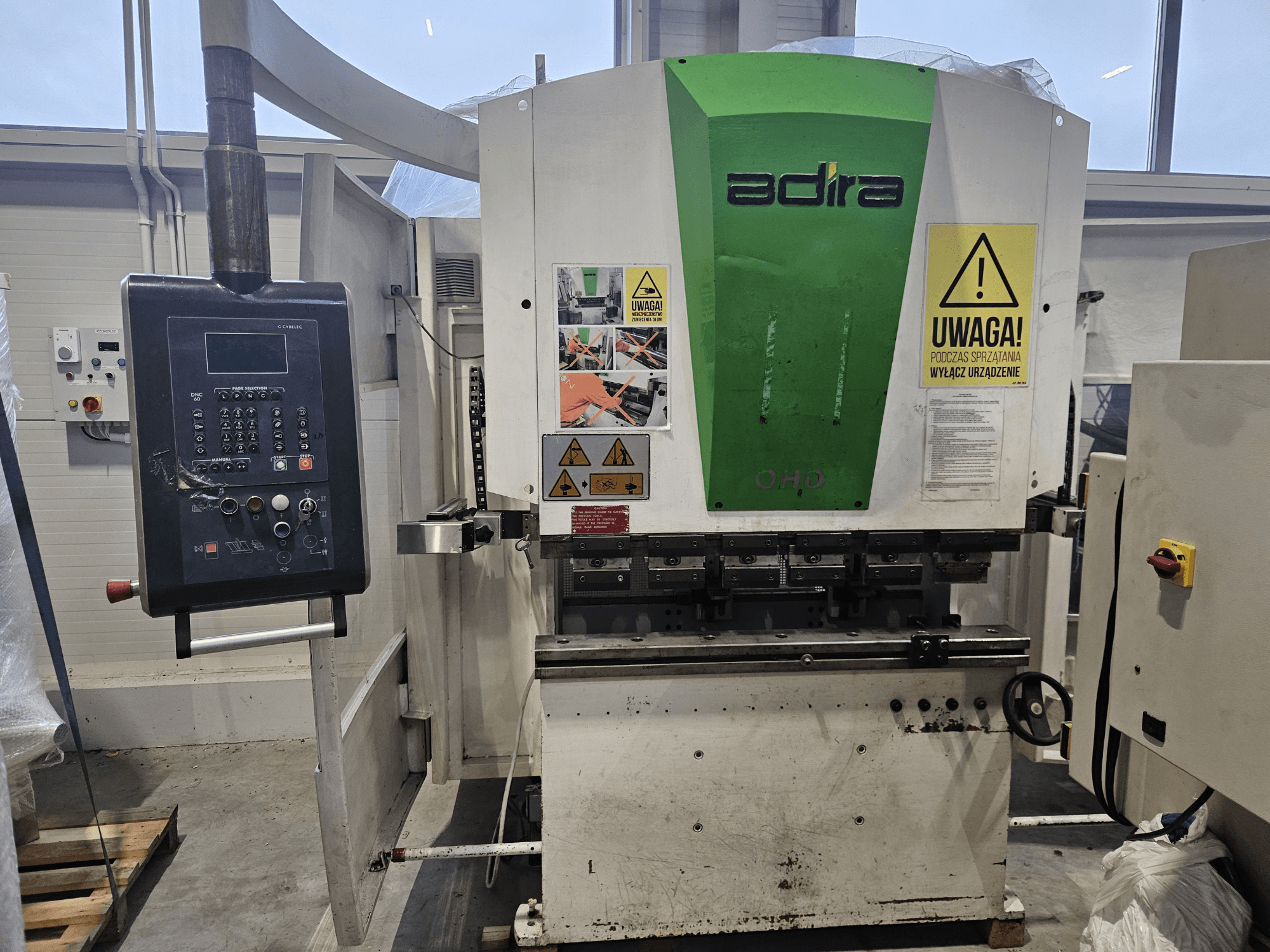 Машина Adira OHD с видом спереди, с панелью управления, предупреждениями о безопасности и кнопками управления.