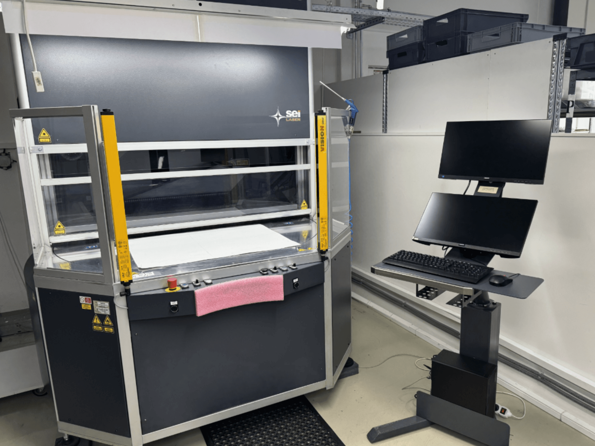 Лазерный резак SEI Laser INFINITY 5070 V300 с CO2-лазером, вид спереди, с панелью управления и подключенной мониторной станцией.