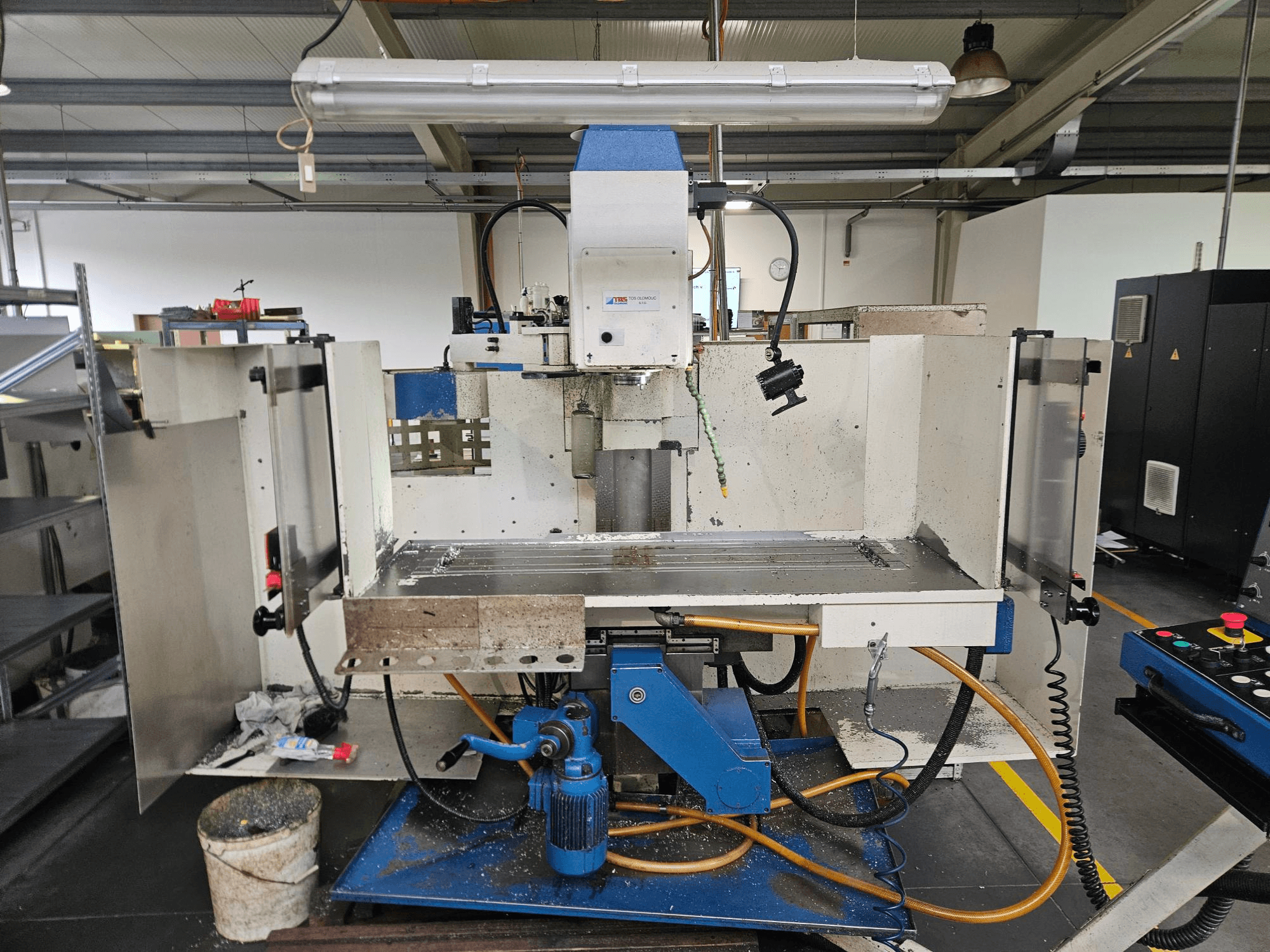TOS Olomouc FV30 CNC Вертикальный обрабатывающий центр в мастерской, вид спереди на панель управления, рабочий стол и систему охлаждения.