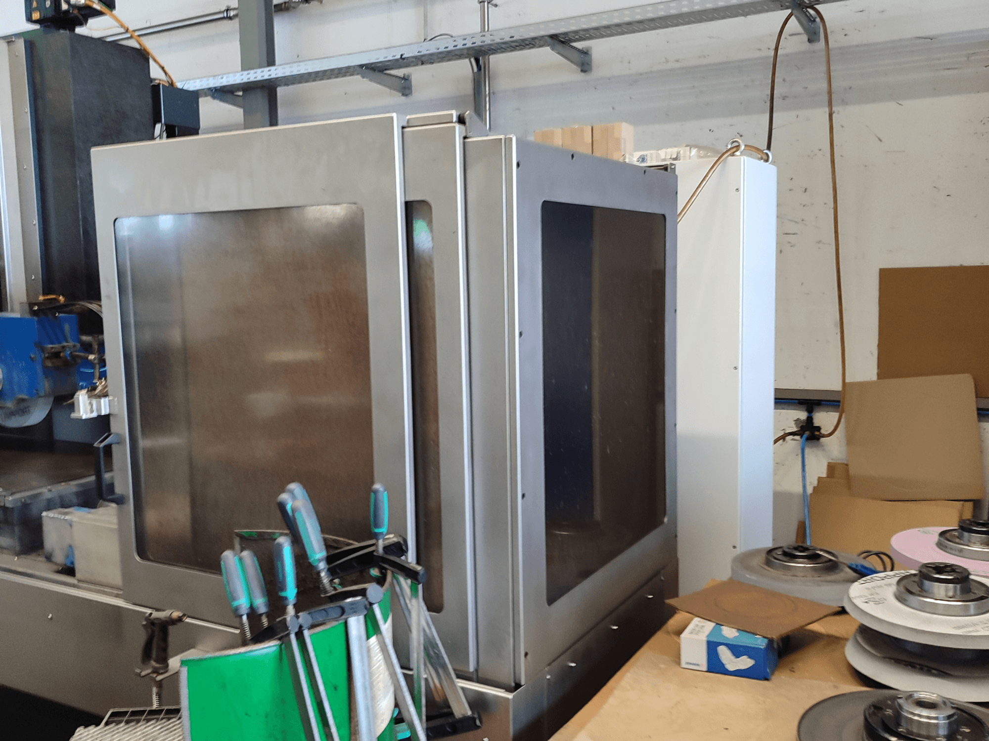 Плоскошлифовальный станок HEINZ STÖCKEL FD 1560 NC-T, вид сбоку на металлический корпус и шлифовальные компоненты в условиях мастерской.