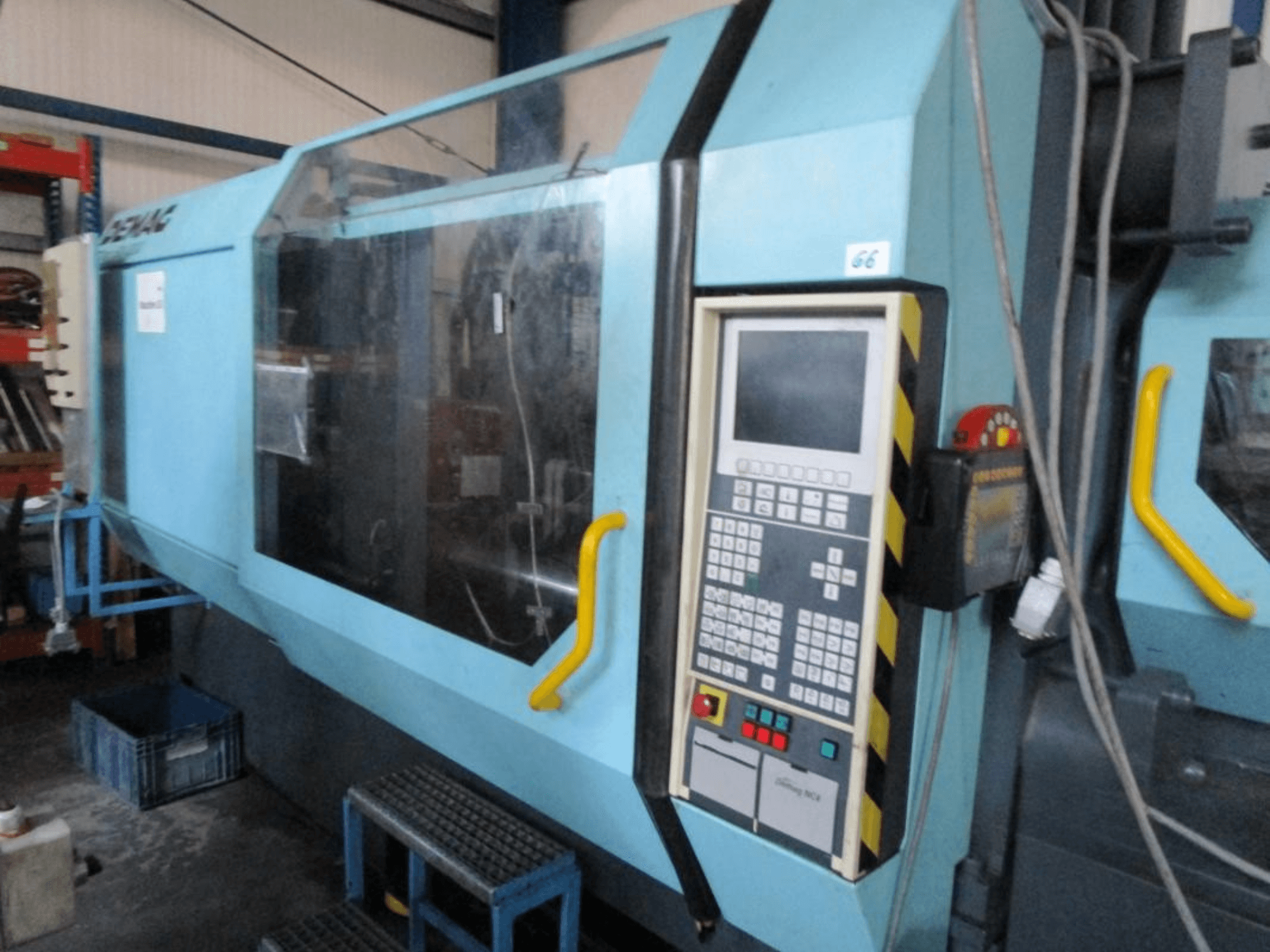 Гидравлическая машина для литья под давлением Demag Erdotech 500-3300, вид спереди, панель управления и прозрачный защитный кожух.