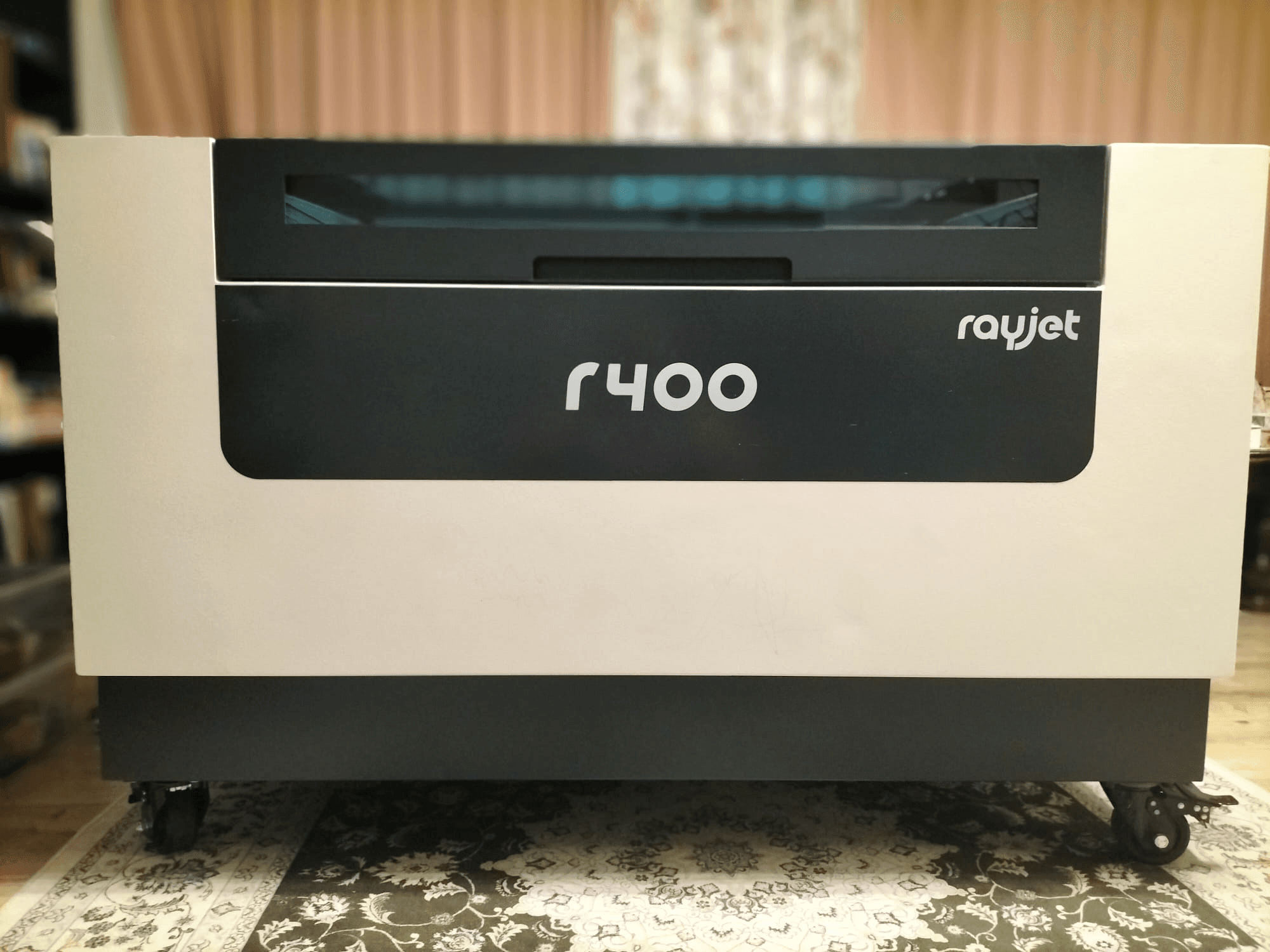 Вид спереди на лазерный гравировальный станок Trotec Rayjet R400, демонстрирующий его элегантный дизайн и четкое брендирование.