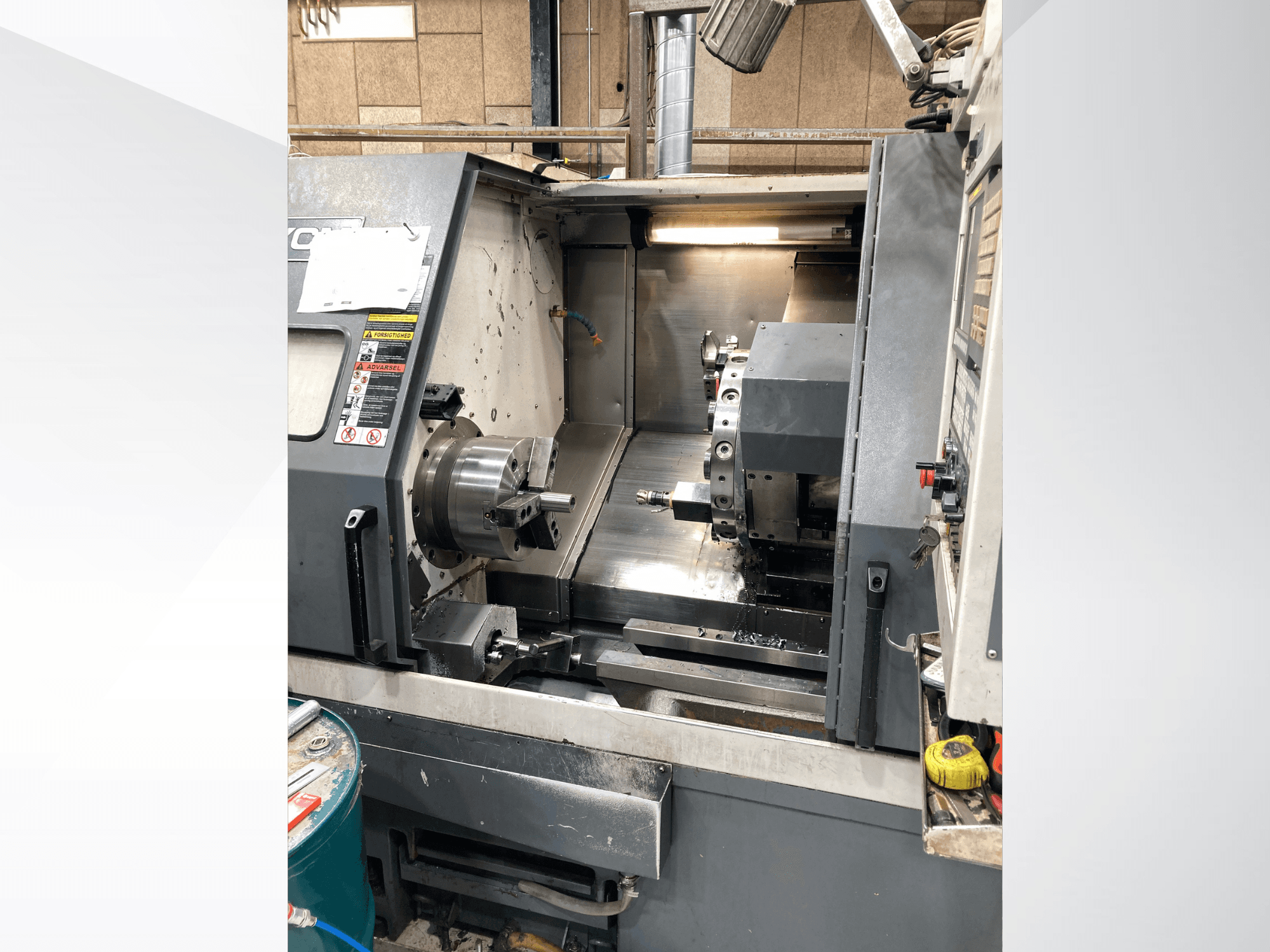 Горизонтальный токарный станок YCM GT-300LMB, вид спереди, демонстрирует панель управления и вращающийся патрон с инструментальной оснасткой.