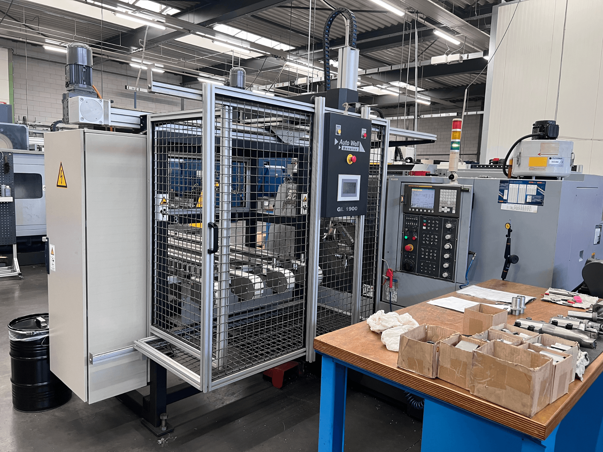 Вид спереди на станок Auto Weld GL 1900 с панелью управления, защитным кожухом и окружающими инструментами на верстаке.