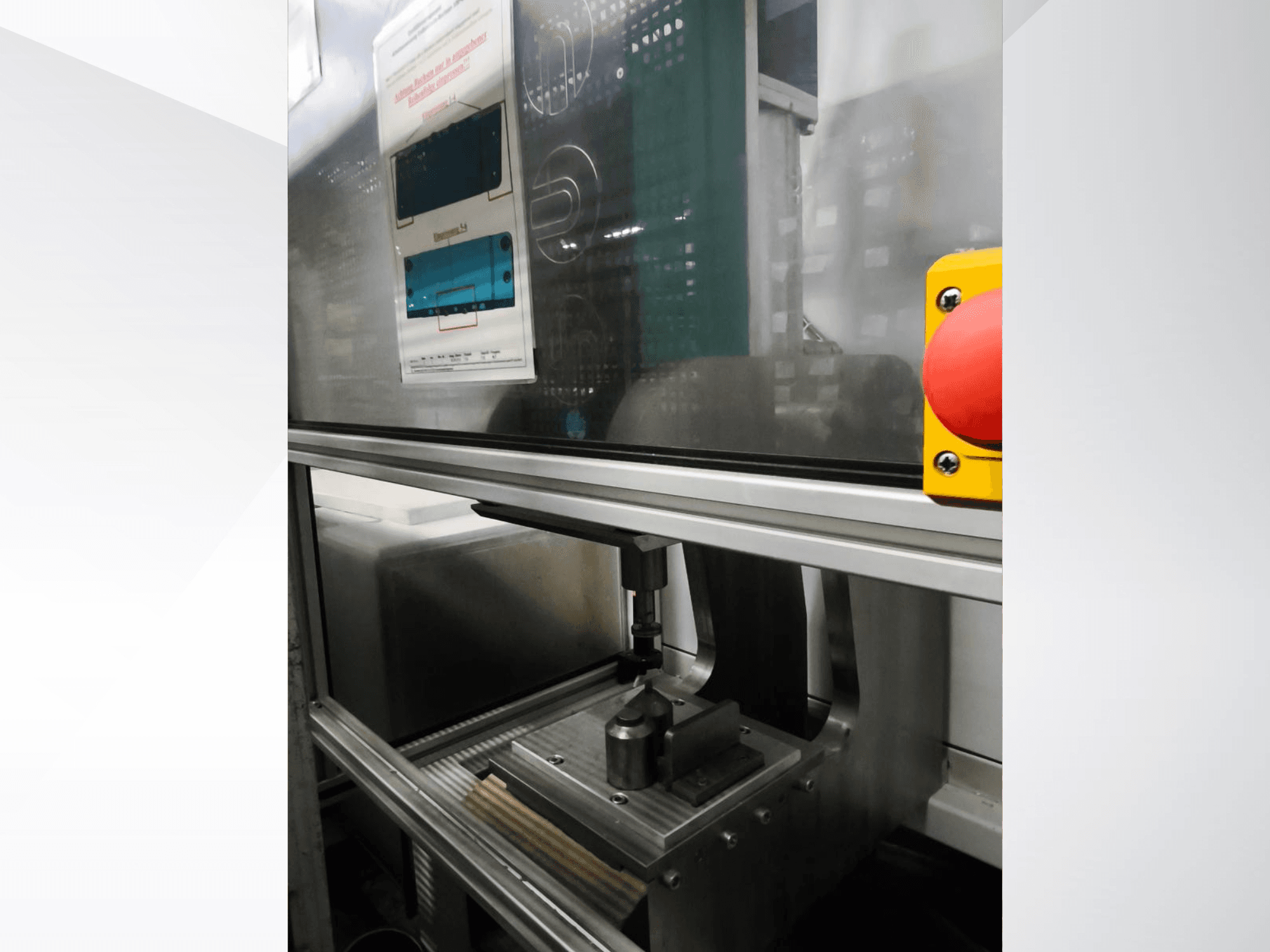 Вид спереди станка EMS Automation Buchsenpresse, демонстрирующий прижимной механизм и кнопку безопасности.