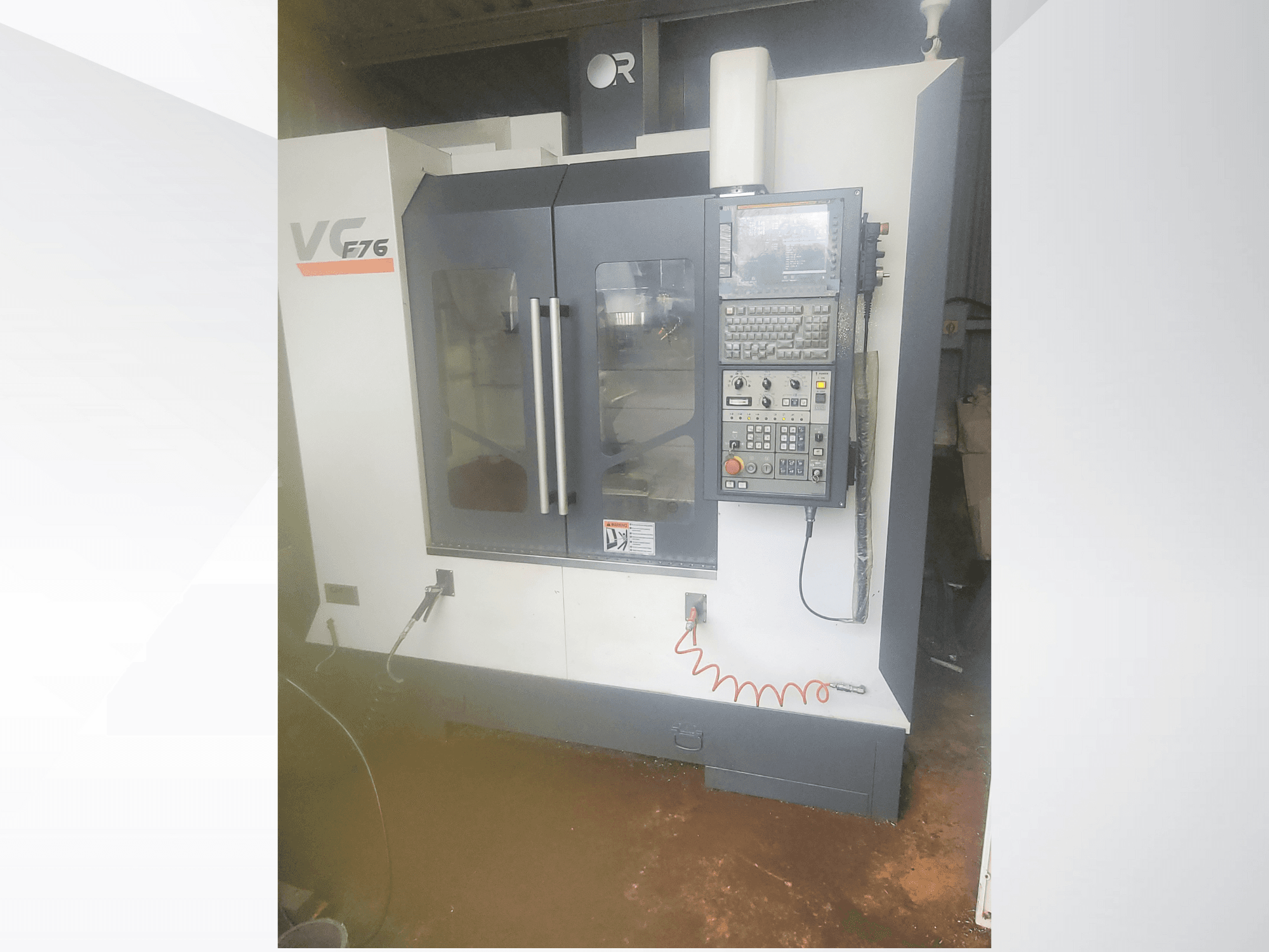 Вертикальный обрабатывающий центр, марка VC, модель F76; вид спереди с изображением панели управления и стеклянных дверей.