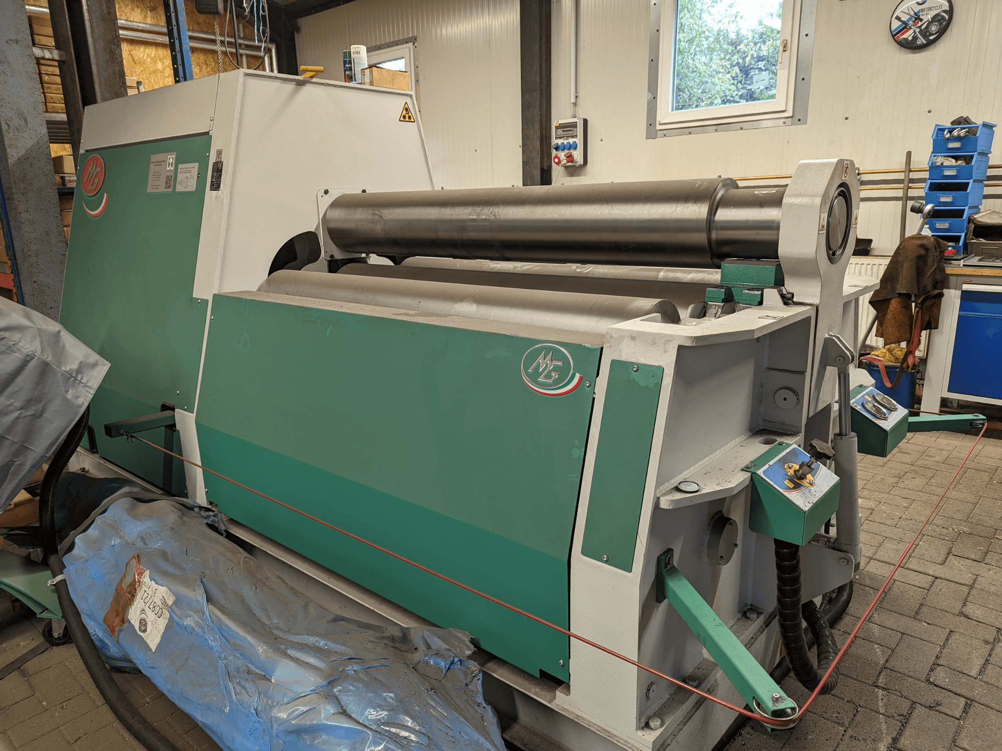 Рулоногибочный станок MG модели MG4R1520C зеленого и серого цвета, вид сбоку, демонстрирующий три металлических валка и панели управления.