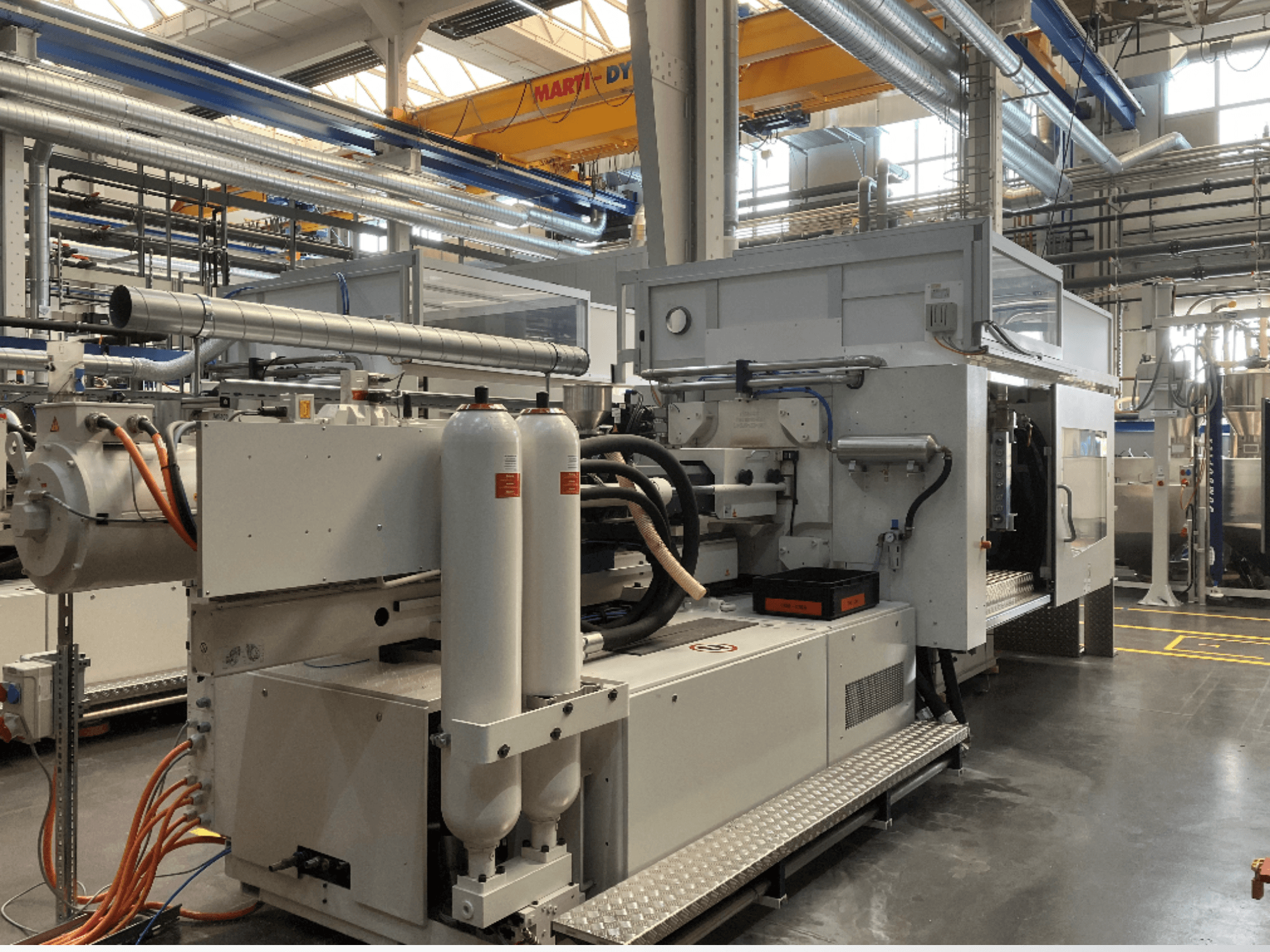 Промышленная машина с несколькими шлангами, двумя вертикальными резервуарами и панелью управления; марка/модель не видна.