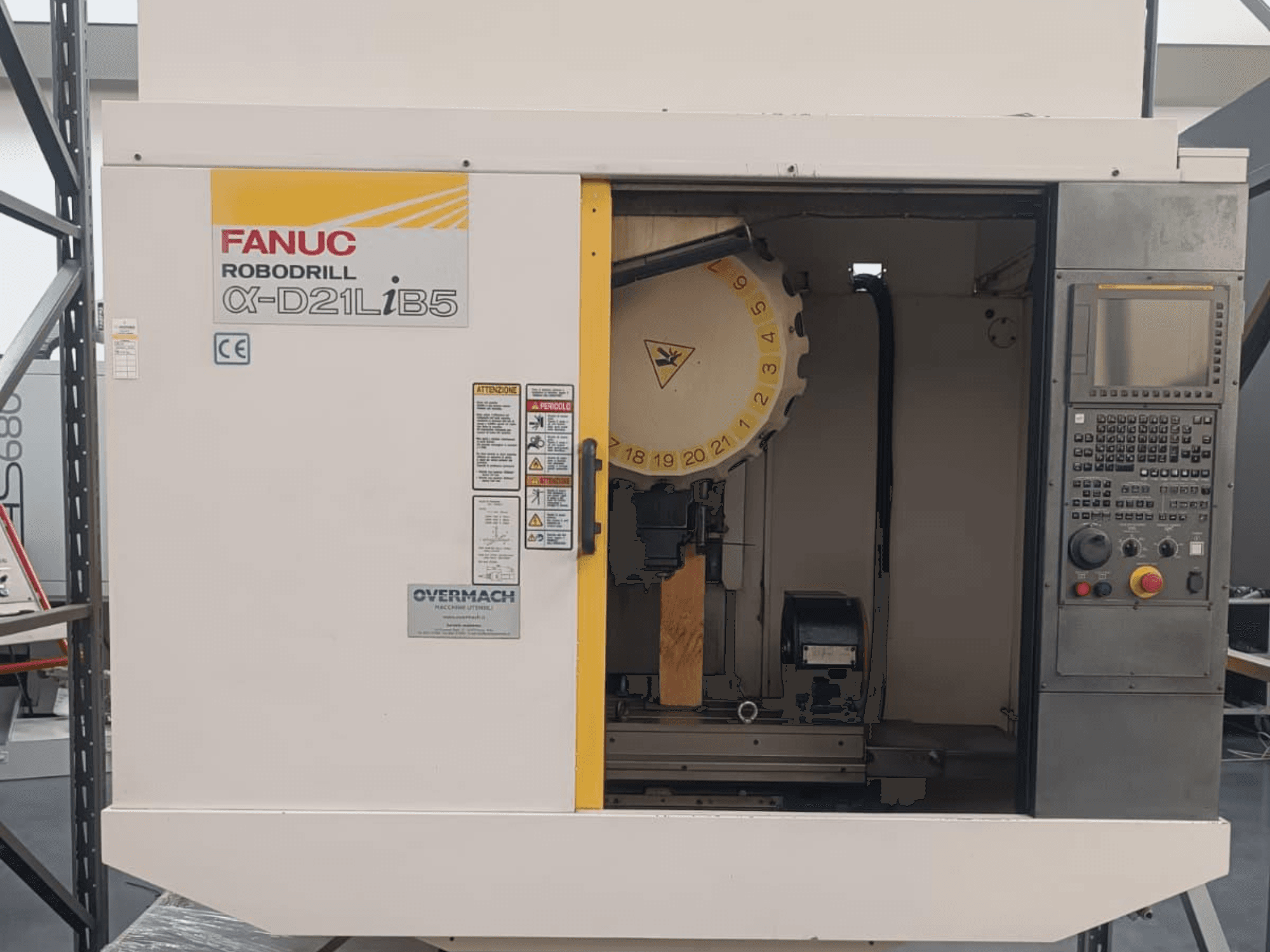 FANUC Robodrill α-D21LiB5, вид спереди; станок с ЧПУ с держателем инструмента, панелью управления и предупреждениями о безопасности.