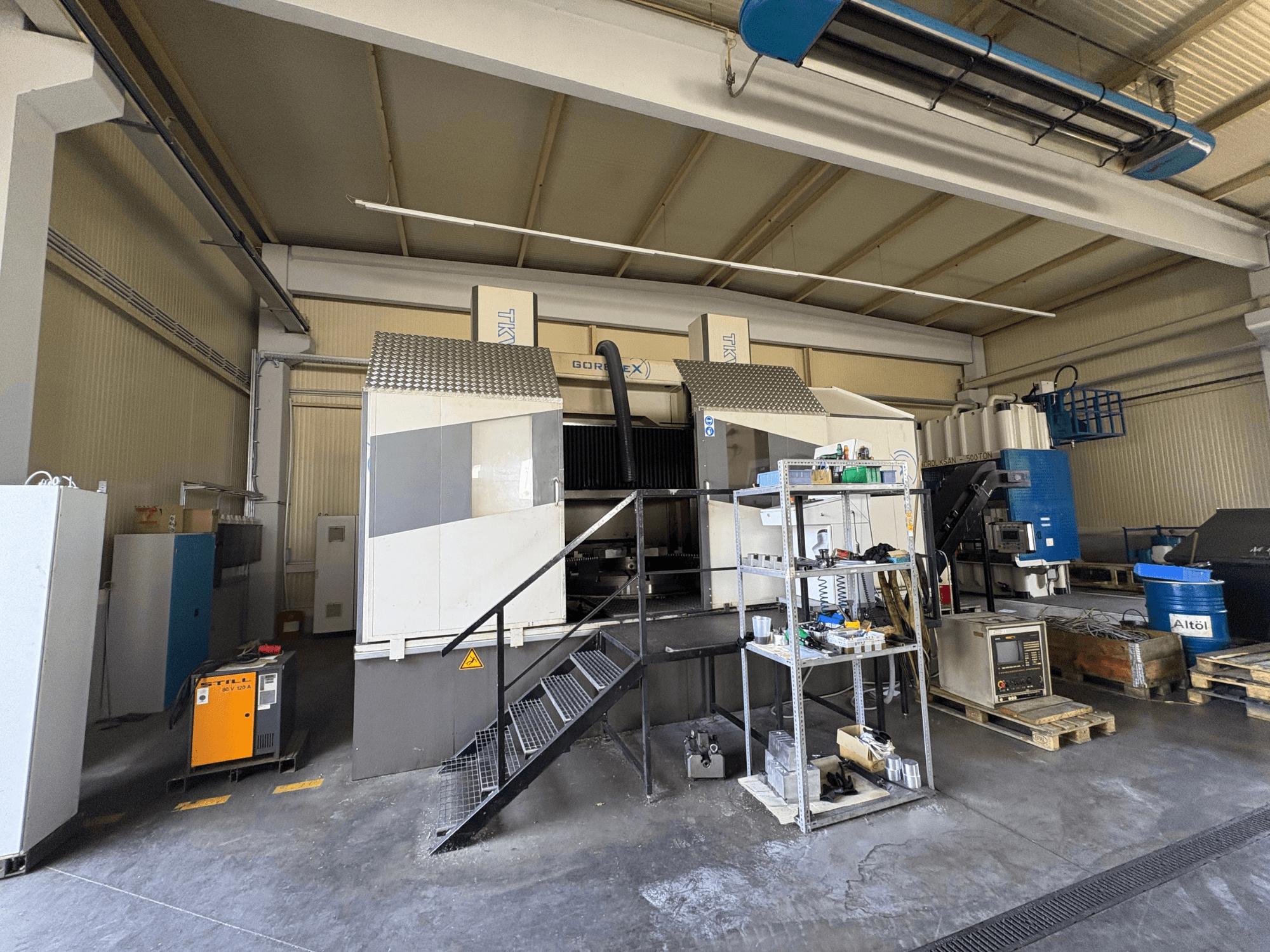 Промышленная установка для обработки на станке GORAT X, вид сбоку; включает инструменты, панель управления и оборудование на полках.