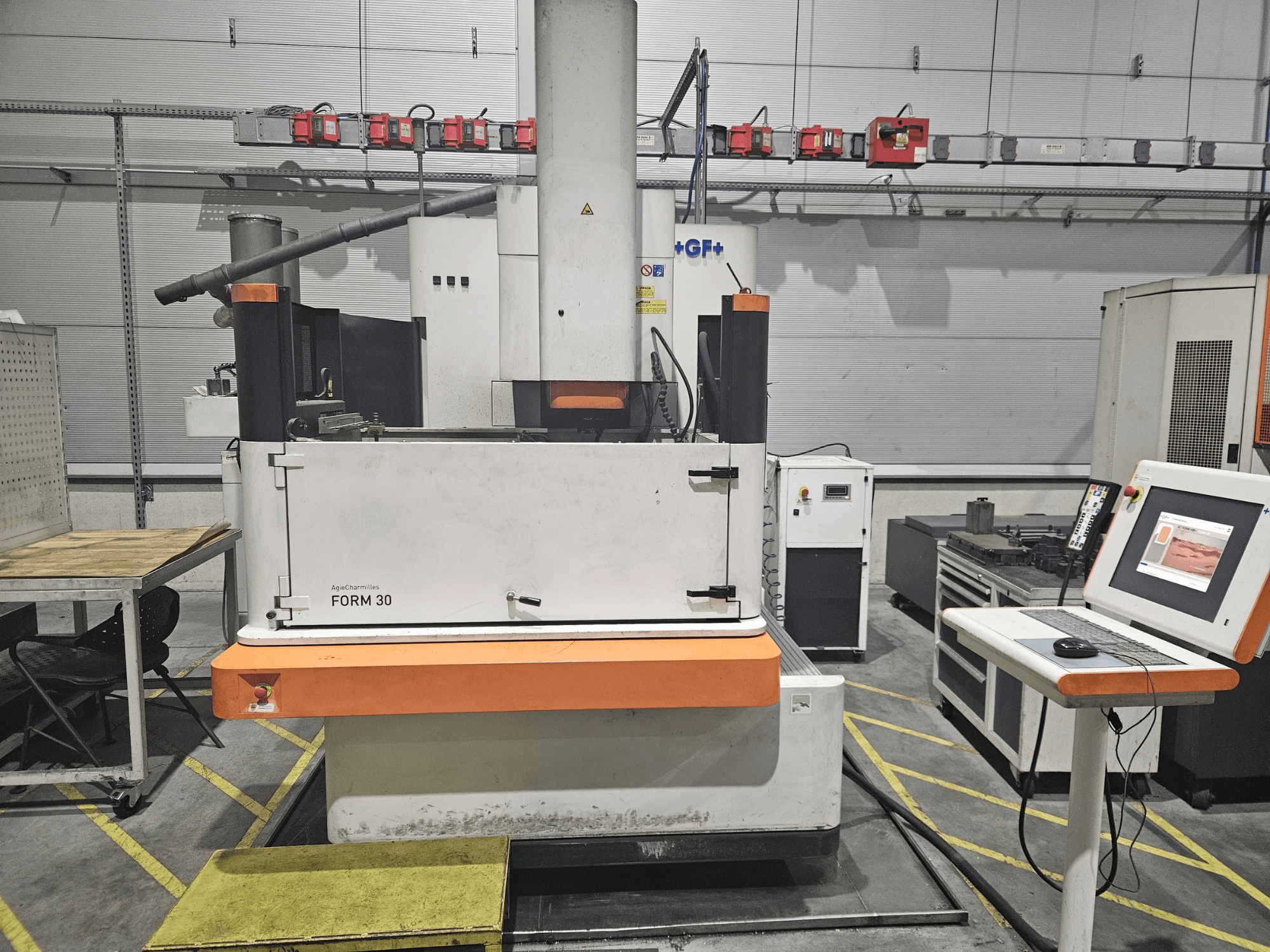 Машина ApeqChemicals FORM 30 в мастерской, вид спереди с панелью управления и рабочим столом сбоку.