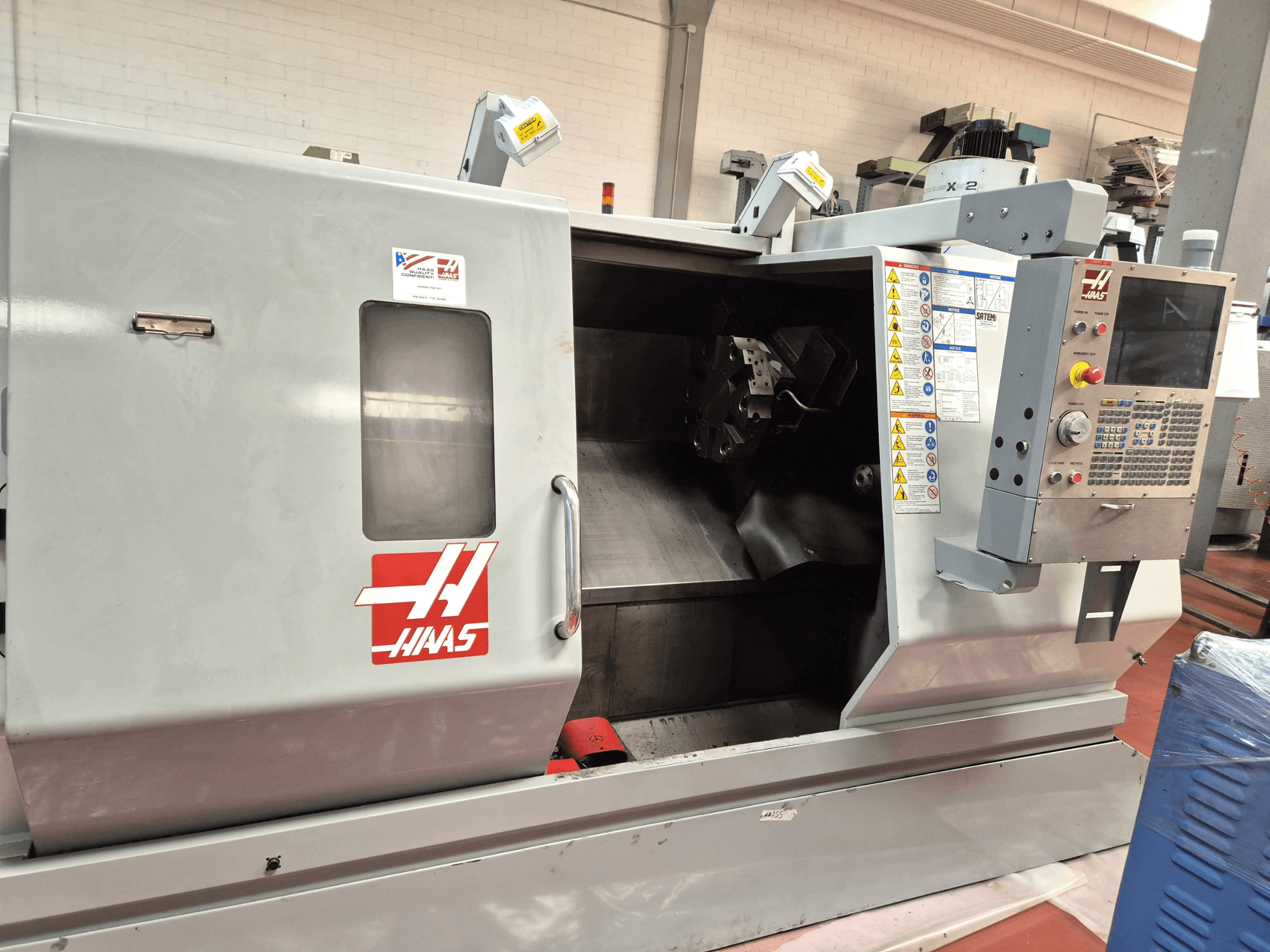 Горизонтальный токарный станок Haas SL 30TBHE, вид спереди, на котором видны органы управления и открытый отсек для проведения токарных операций.
