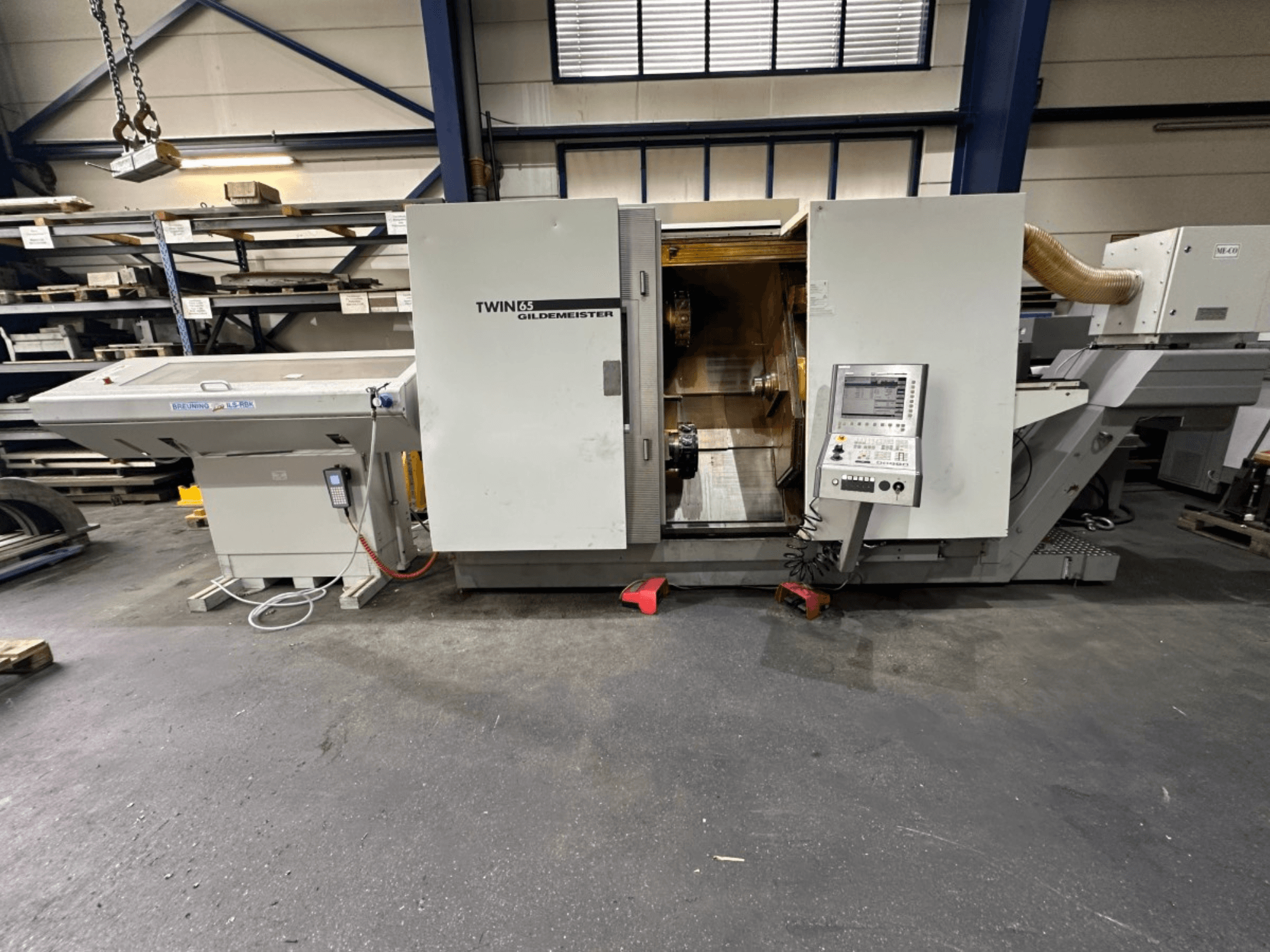Горизонтальный токарный станок Gildemeister TWIN 65, вид спереди; панель управления и видимая внутренняя часть для обработки деталей.