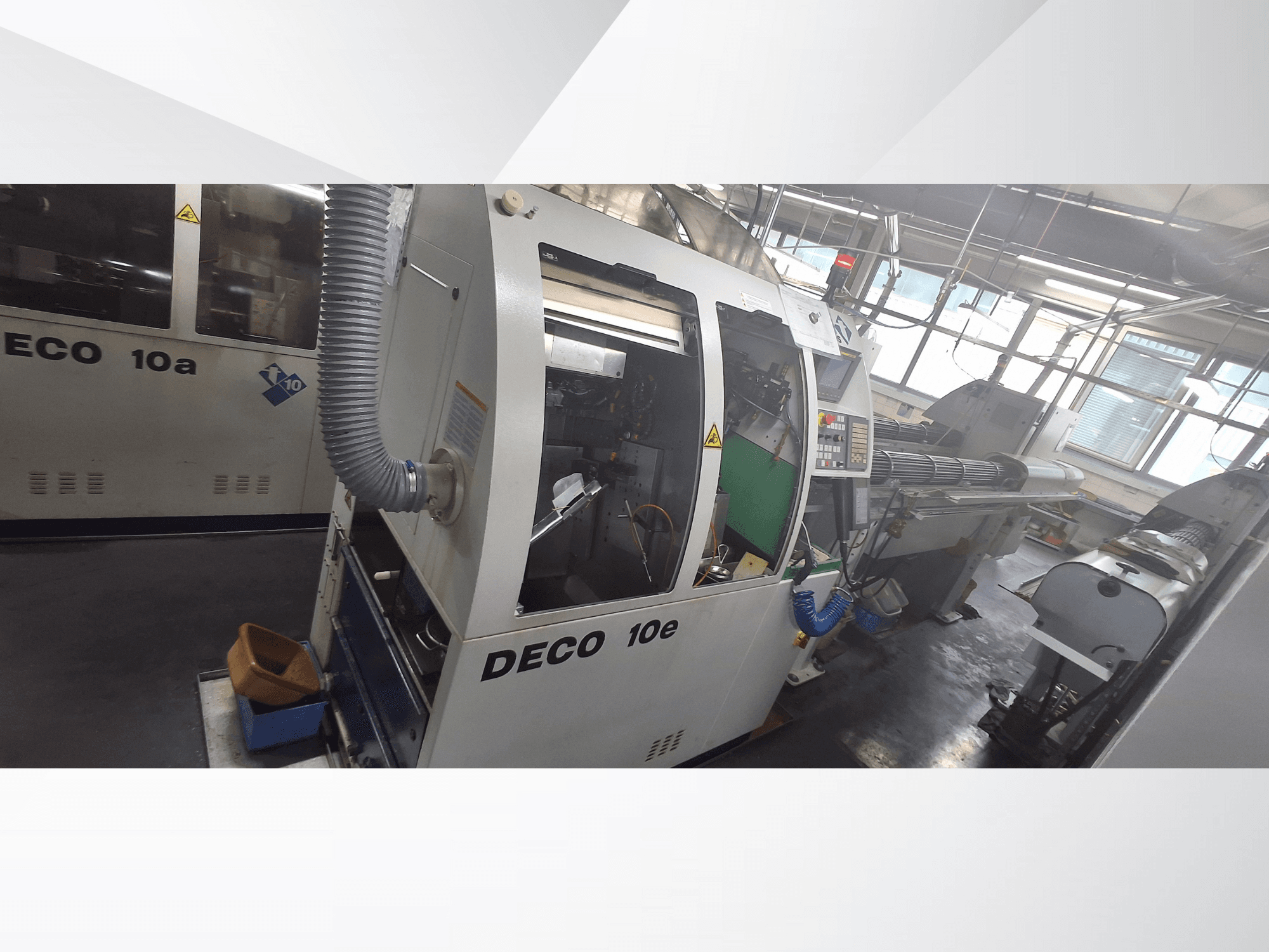 Станок с ЧПУ DECO 10e с видом сбоку, с панелью управления, зеленым интерьером и подключенным выхлопным шлангом.