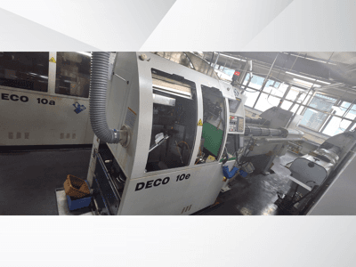 Станок с ЧПУ DECO 10e с видом сбоку, с панелью управления, зеленым интерьером и подключенным выхлопным шлангом.