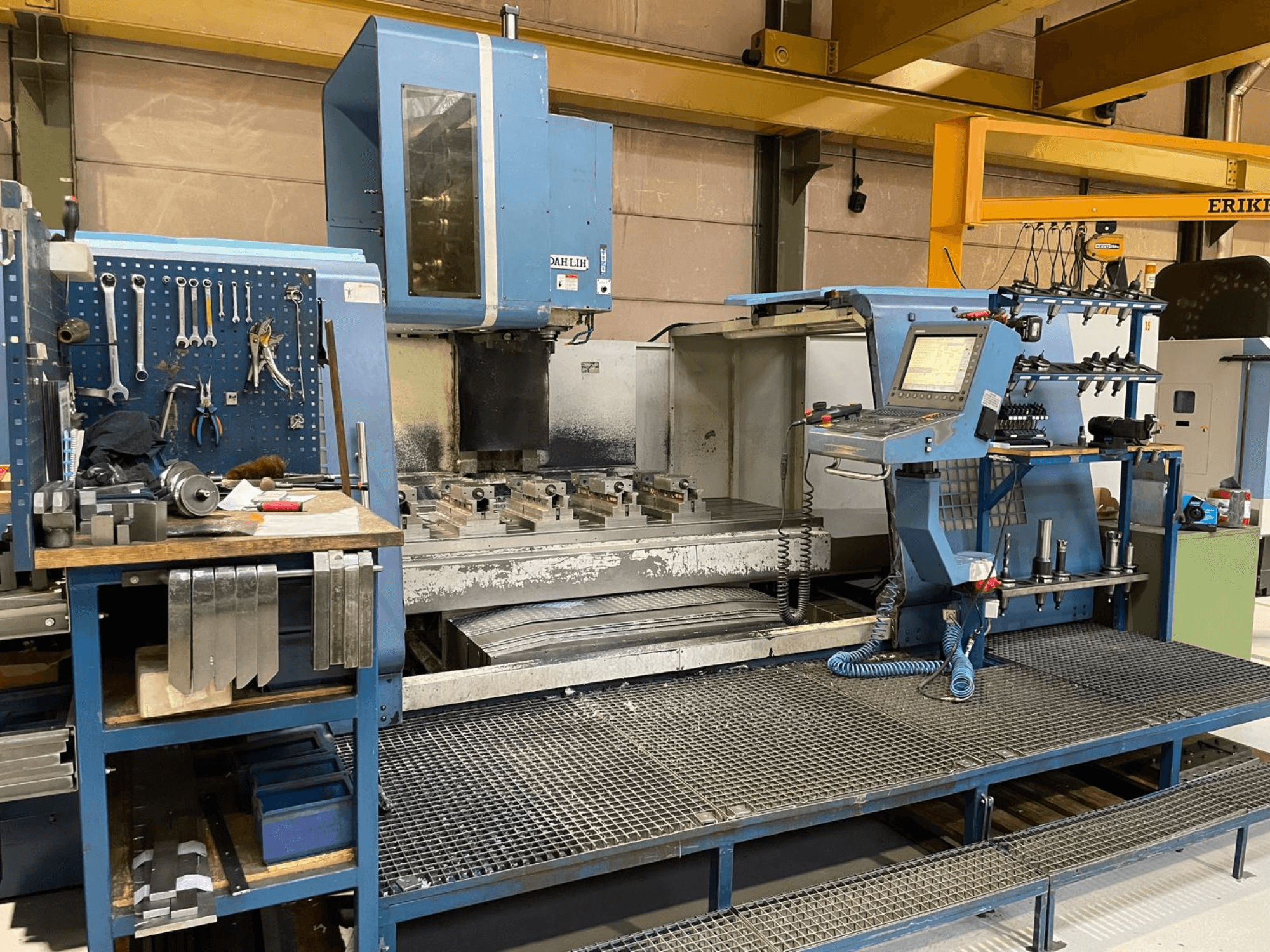 Вид спереди вертикального обрабатывающего центра DAH LIH MCV2600, демонстрирующий панель управления, рабочий стол и зону хранения инструментов.