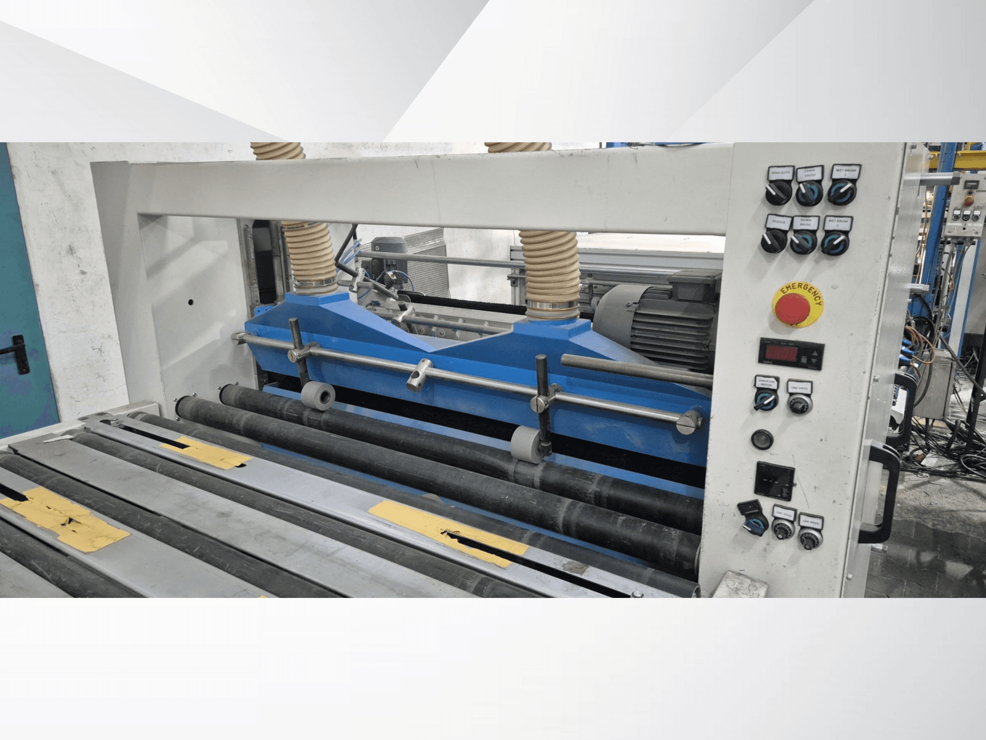 Промышленный прокатный станок с синими компонентами, вид спереди, с панелью управления и кнопкой аварийной остановки.