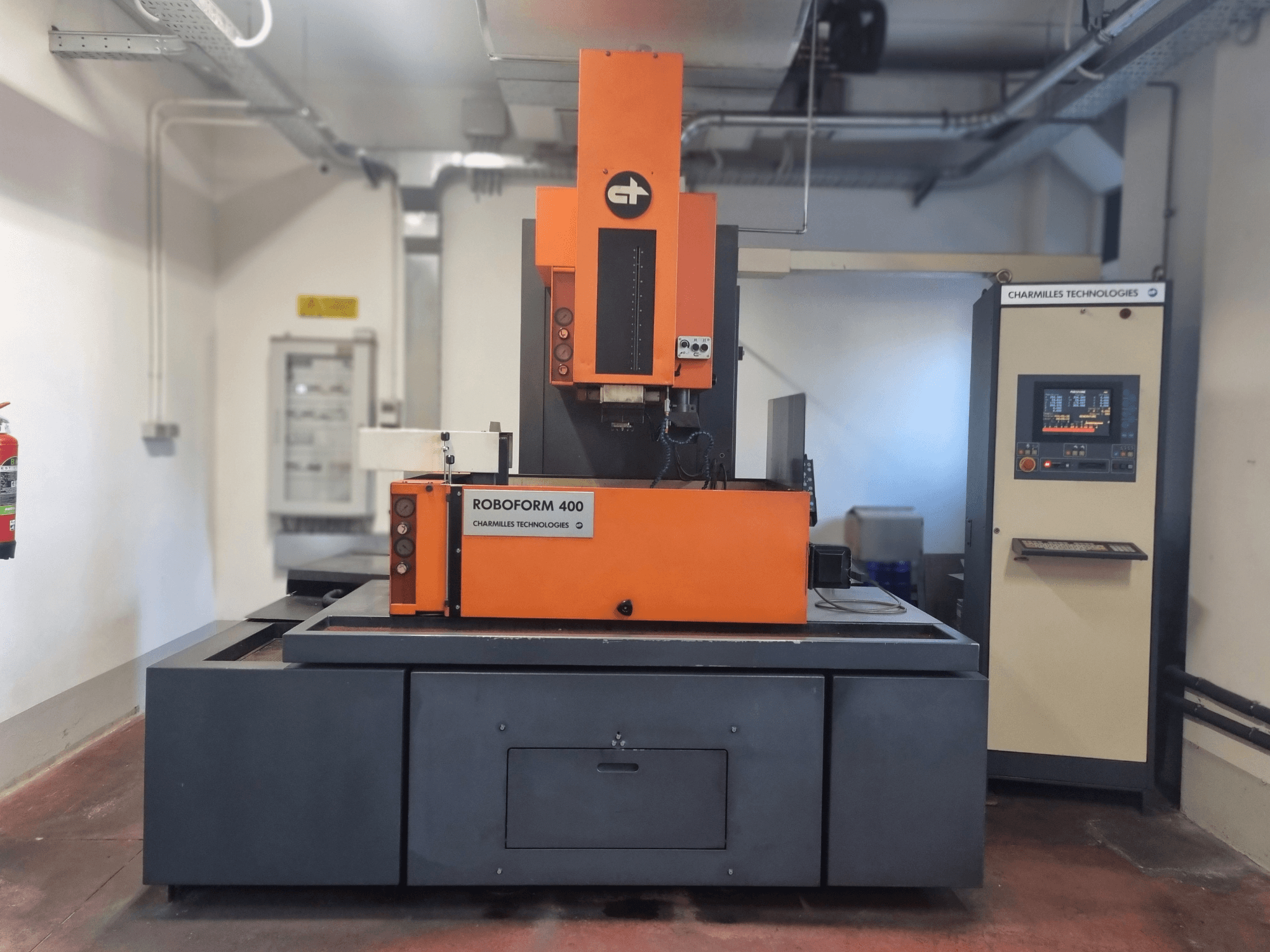 Машина Roboforn 400 от Charmilles Technologies, вид спереди, оранжево-серый дизайн, видна цифровая панель управления.