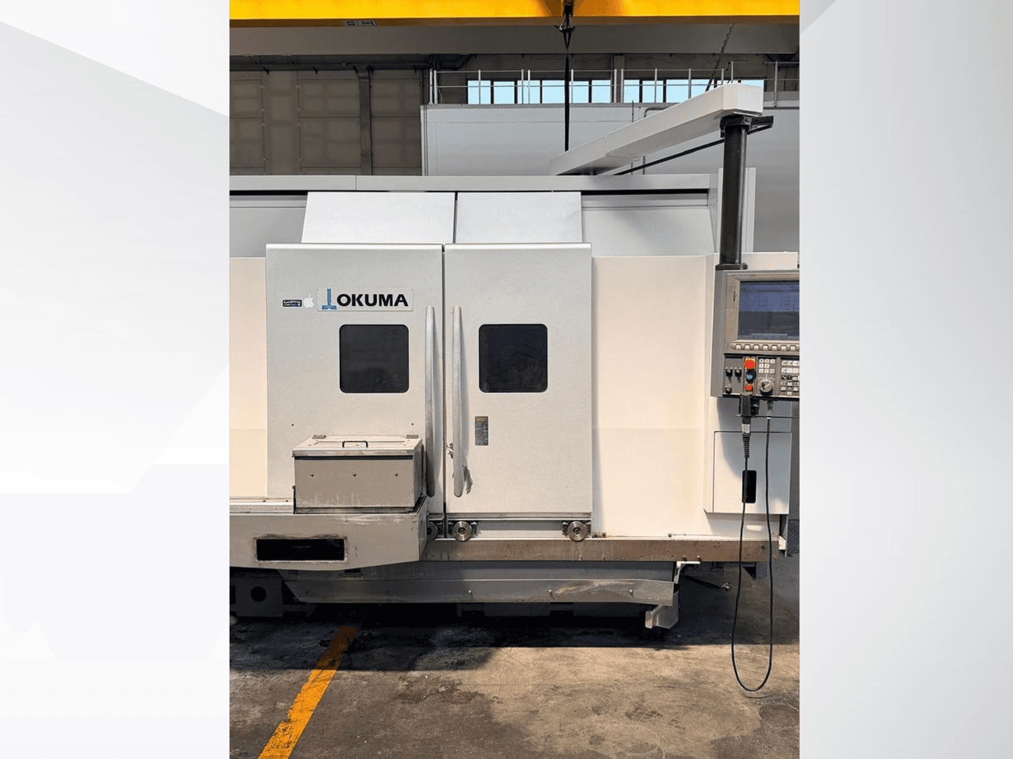 Горизонтальный токарный станок Okuma LB 3000 EX MYW 800, вид сбоку, на котором видны панель управления и люки доступа.