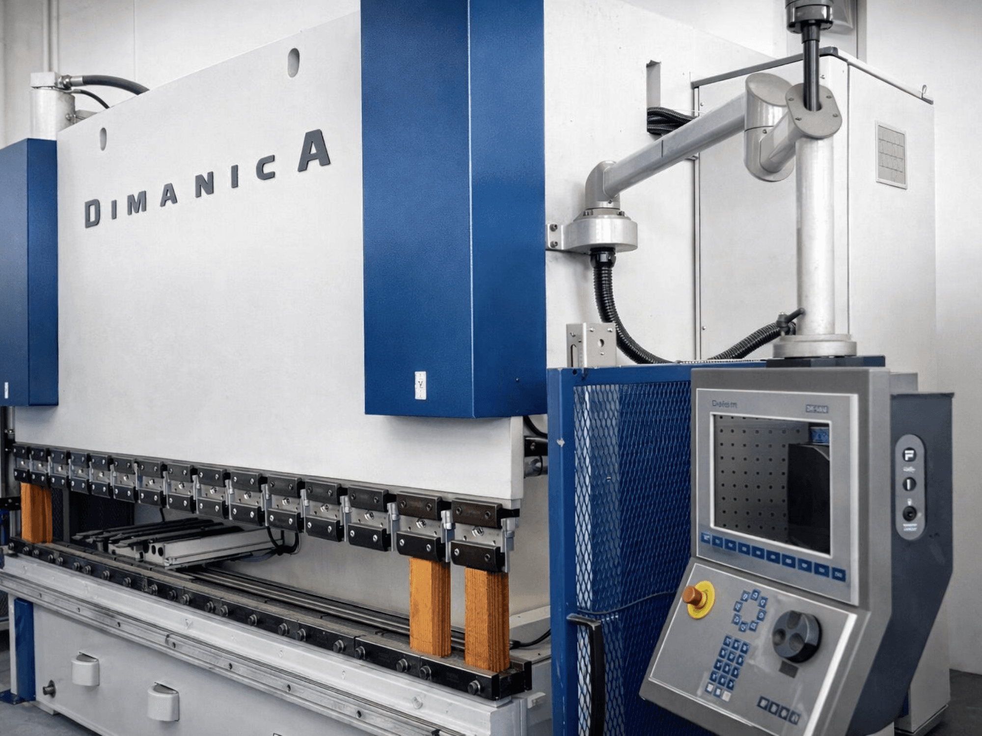 Листогибочный пресс DINAMICA 3000x100 производства Warcom, вид сбоку, демонстрирующий панель управления и гибочные инструменты для изготовления металлоконструкций.