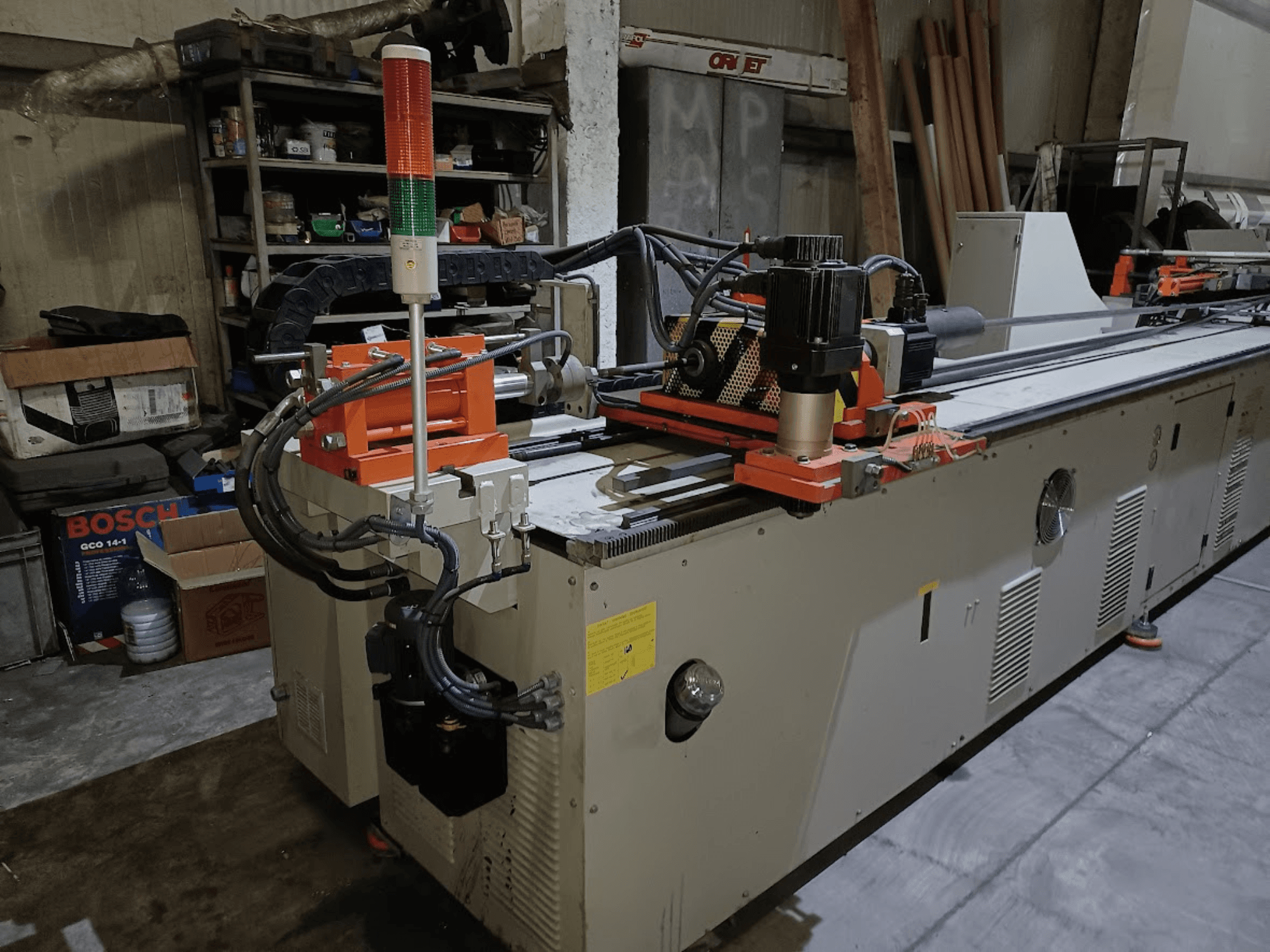 Машина для гибки листового металла CANSA CNC 51 R1, вид сбоку, на котором видны панель управления, двигатель и сигнальные лампочки в условиях цеха.