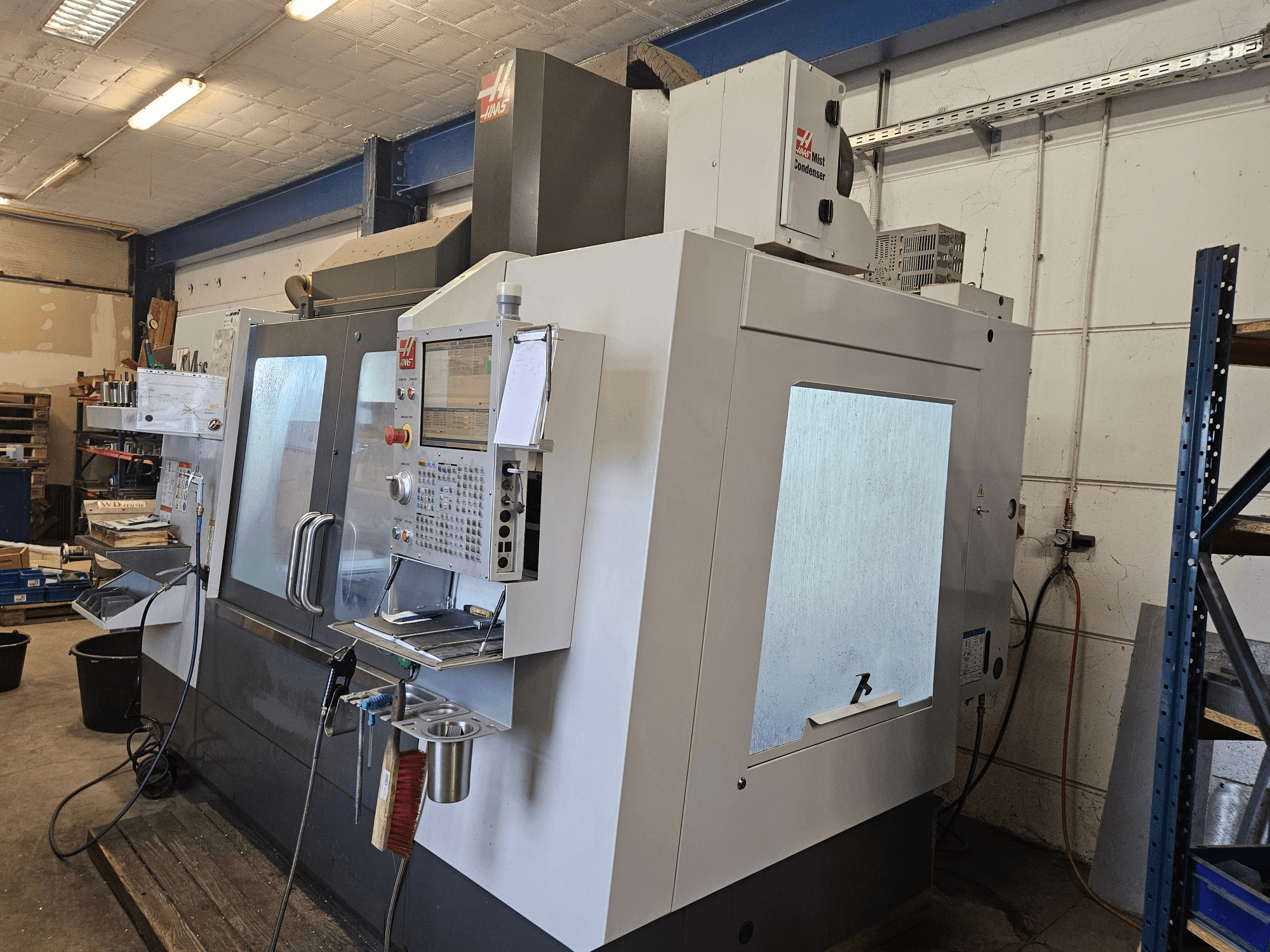 Вертикальный обрабатывающий центр HAAS VF-4SS в виде спереди, с панелью управления и большими смотровыми окнами.