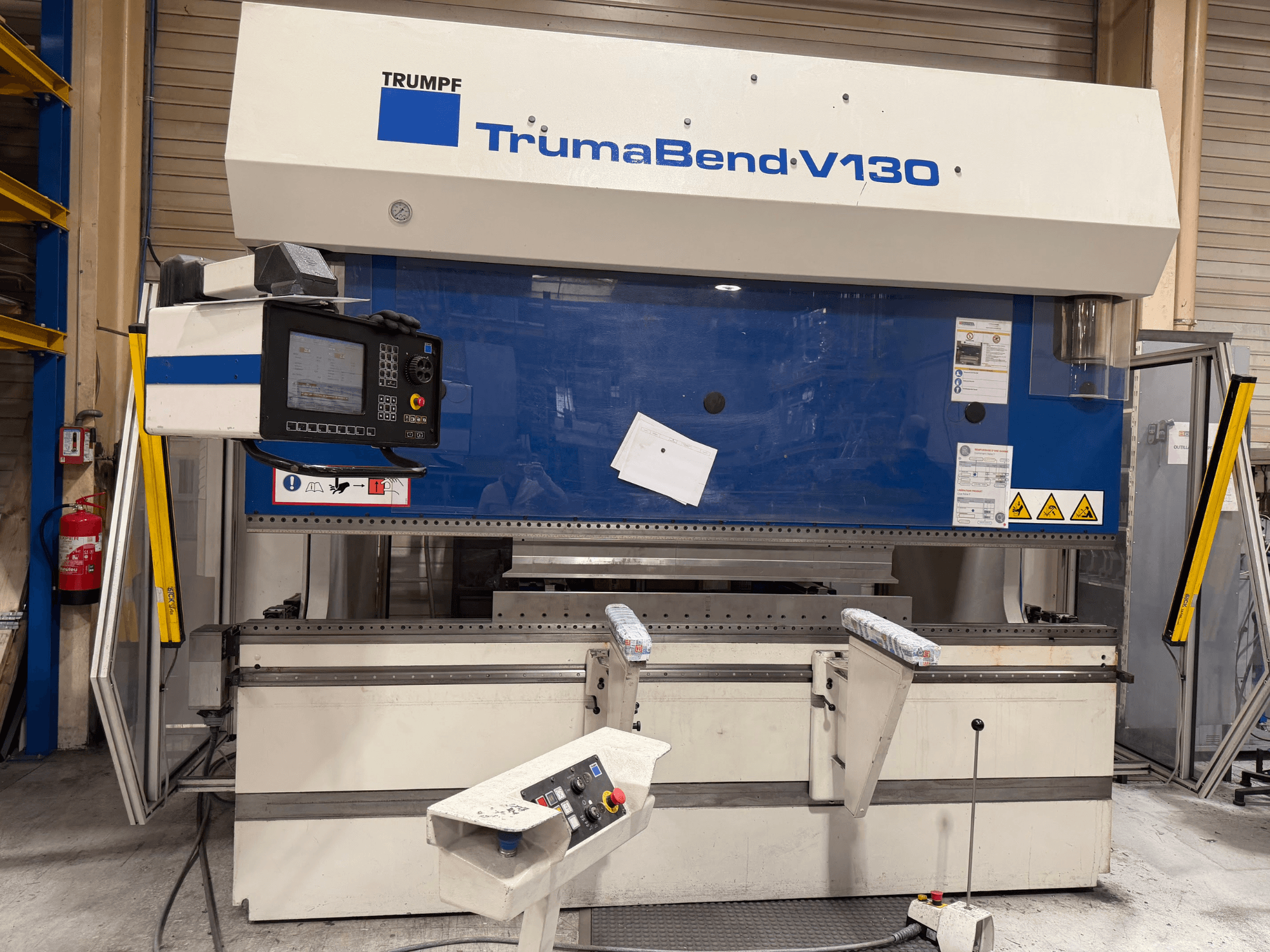 Гибочный пресс TRUMPF TrumaBend V130 в заводской комплектации с панелью управления и средствами безопасности, вид спереди.