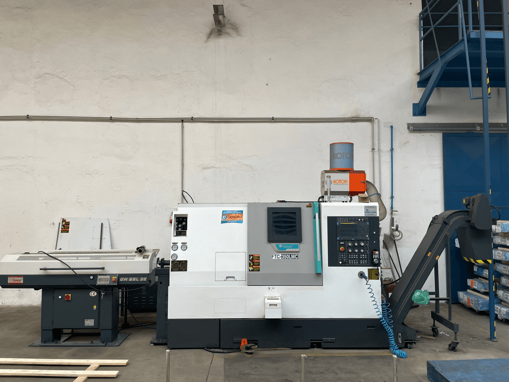 Горизонтальный токарный станок Feeler FTC 350 LMC в мастерской, демонстрирует панель управления и линии подачи инструмента. Вид сбоку.