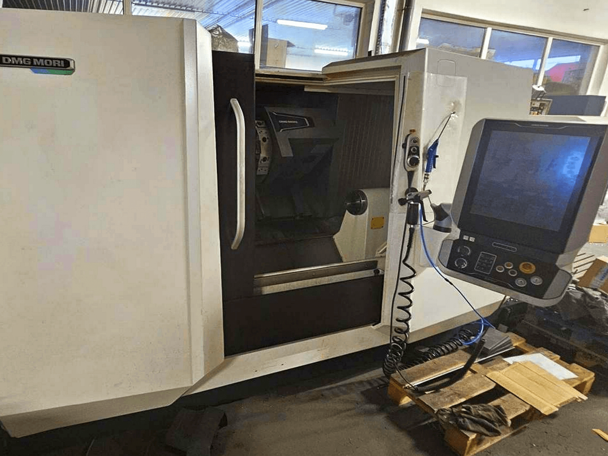 Горизонтальный токарный станок DMG MORI CLX 450 V4, вид спереди с панелью управления, демонстрирующей рабочее пространство и дизайн корпуса.