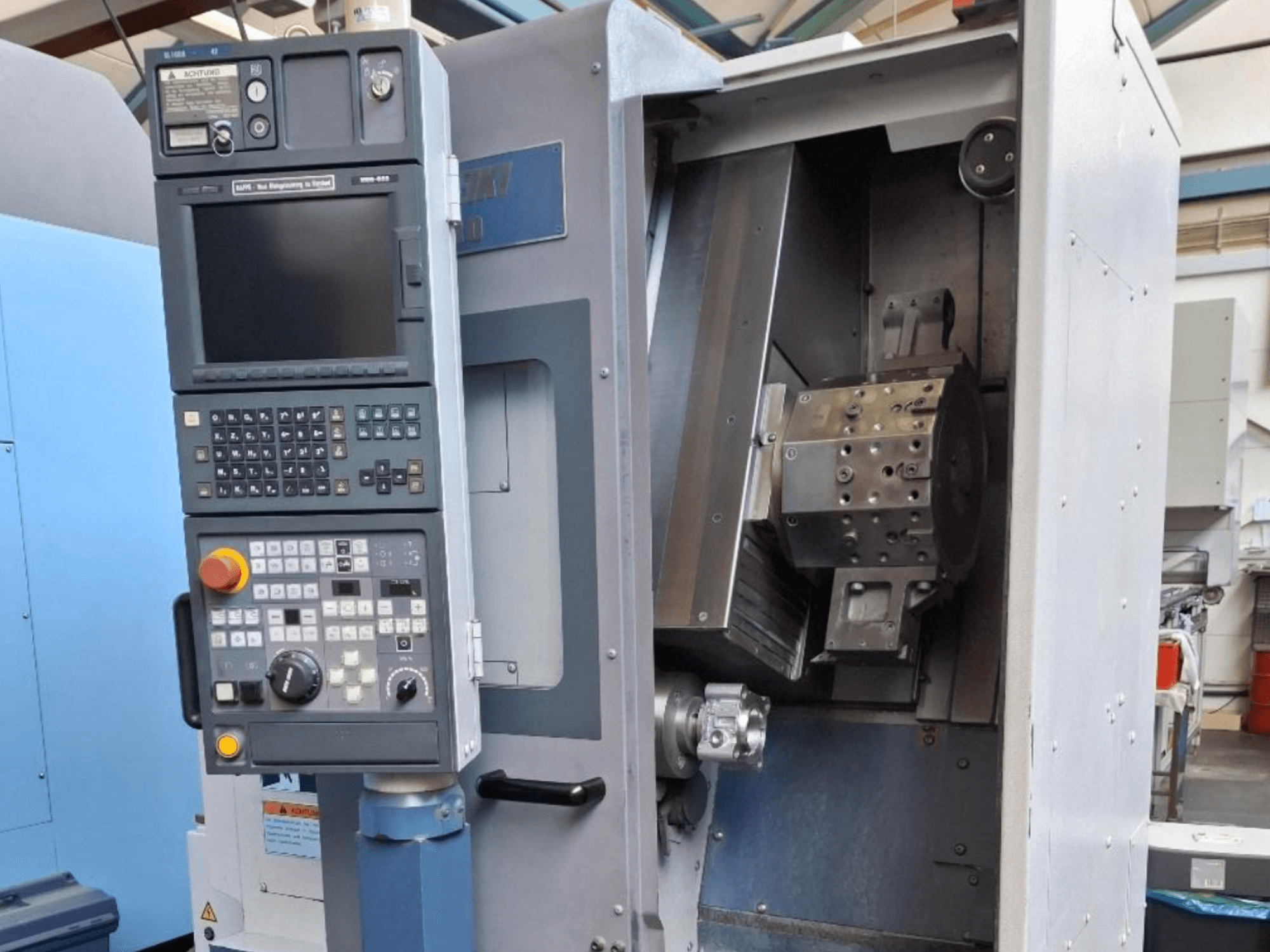 Горизонтальный токарный станок MORI SEIKI SL 1000 вид спереди, панель управления и детализированный внутренний механизм.