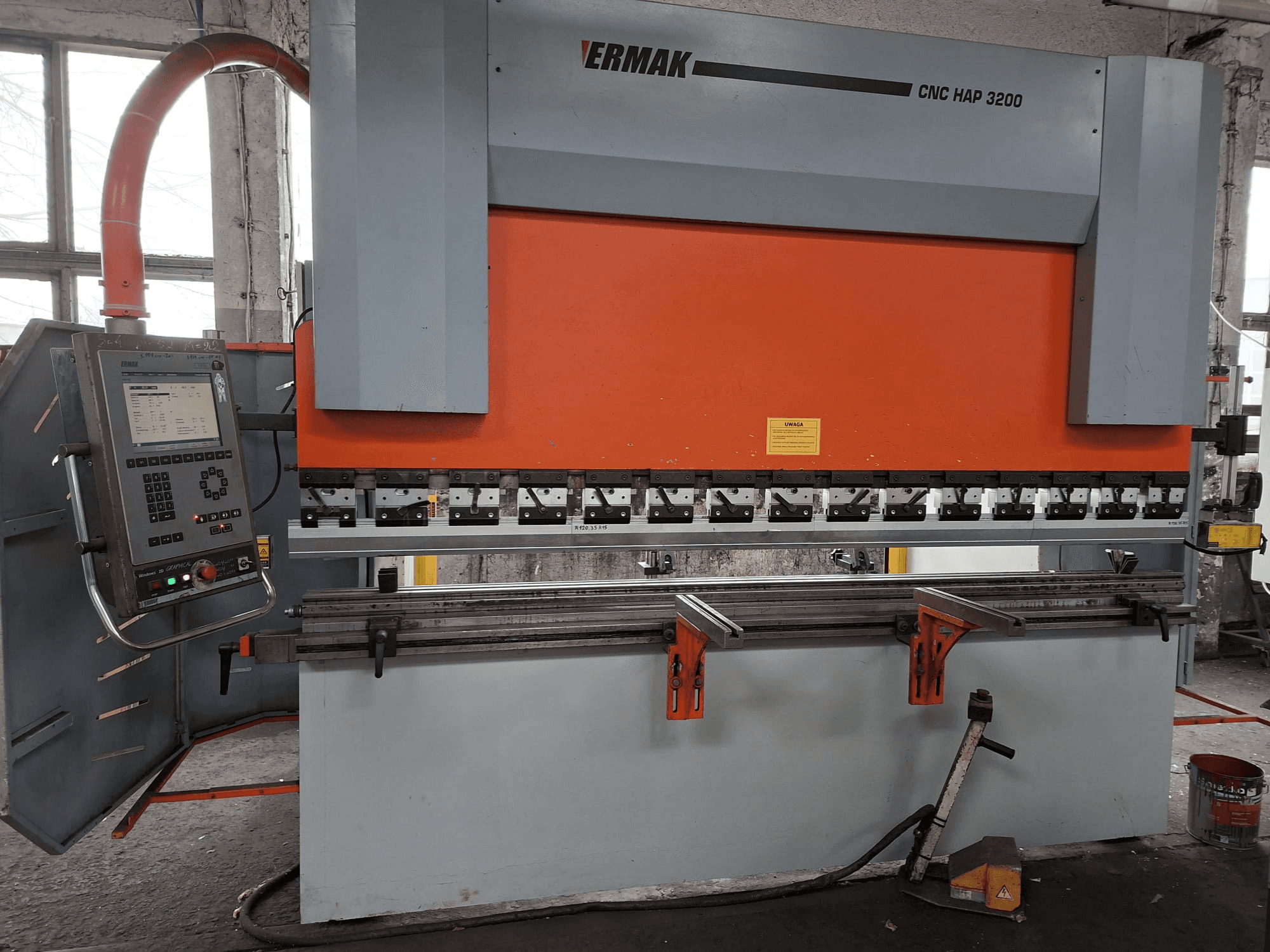 Листогибочный станок Ermak CNC HAP 3200, вид спереди, имеет оранжево-серый корпус, панель управления с цифровым дисплеем и регулируемые зажимы.