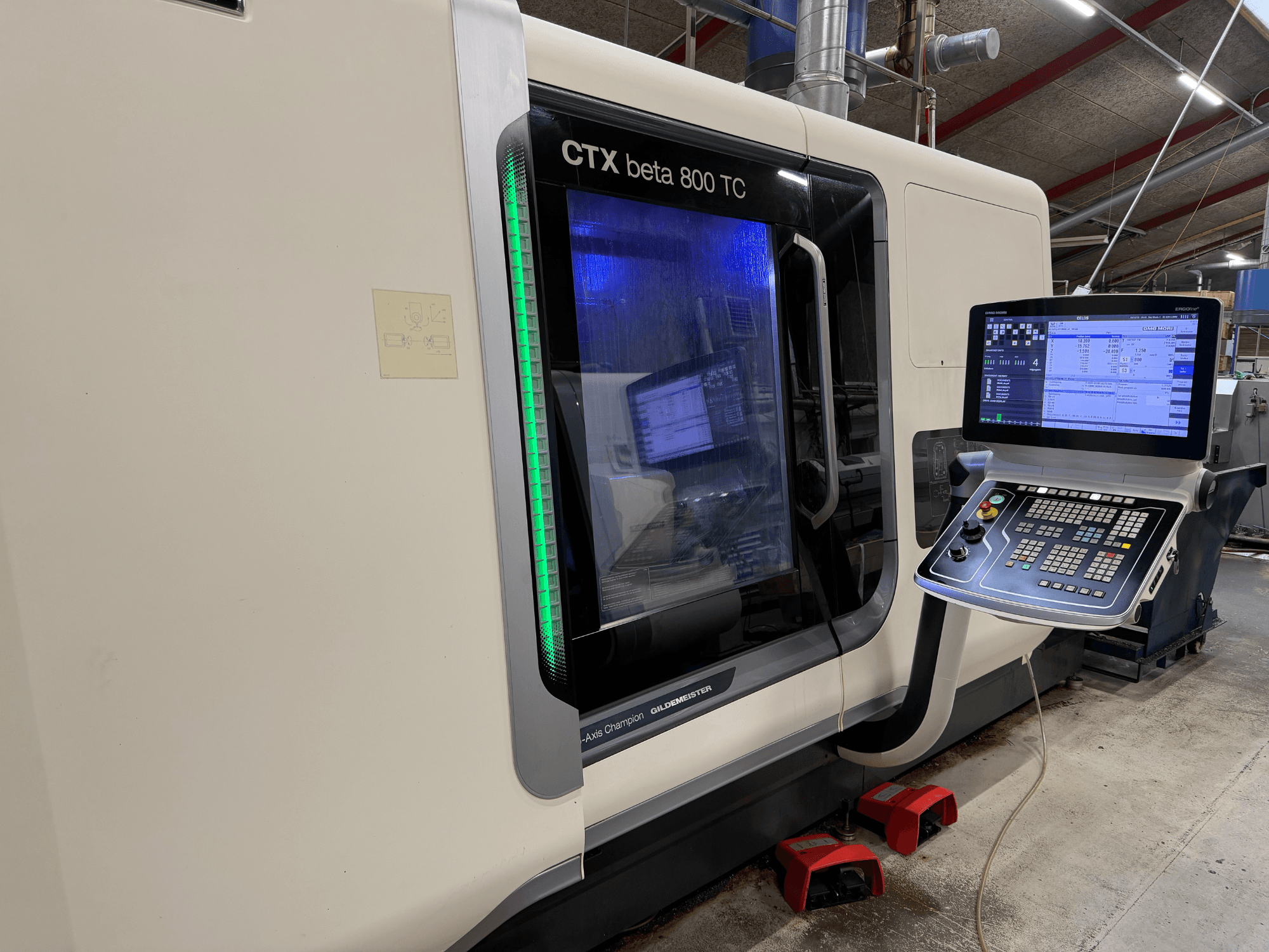 Станок с ЧПУ CTX beta 800 TC с видом сбоку, с цифровой панелью управления и зеленым индикатором безопасности.