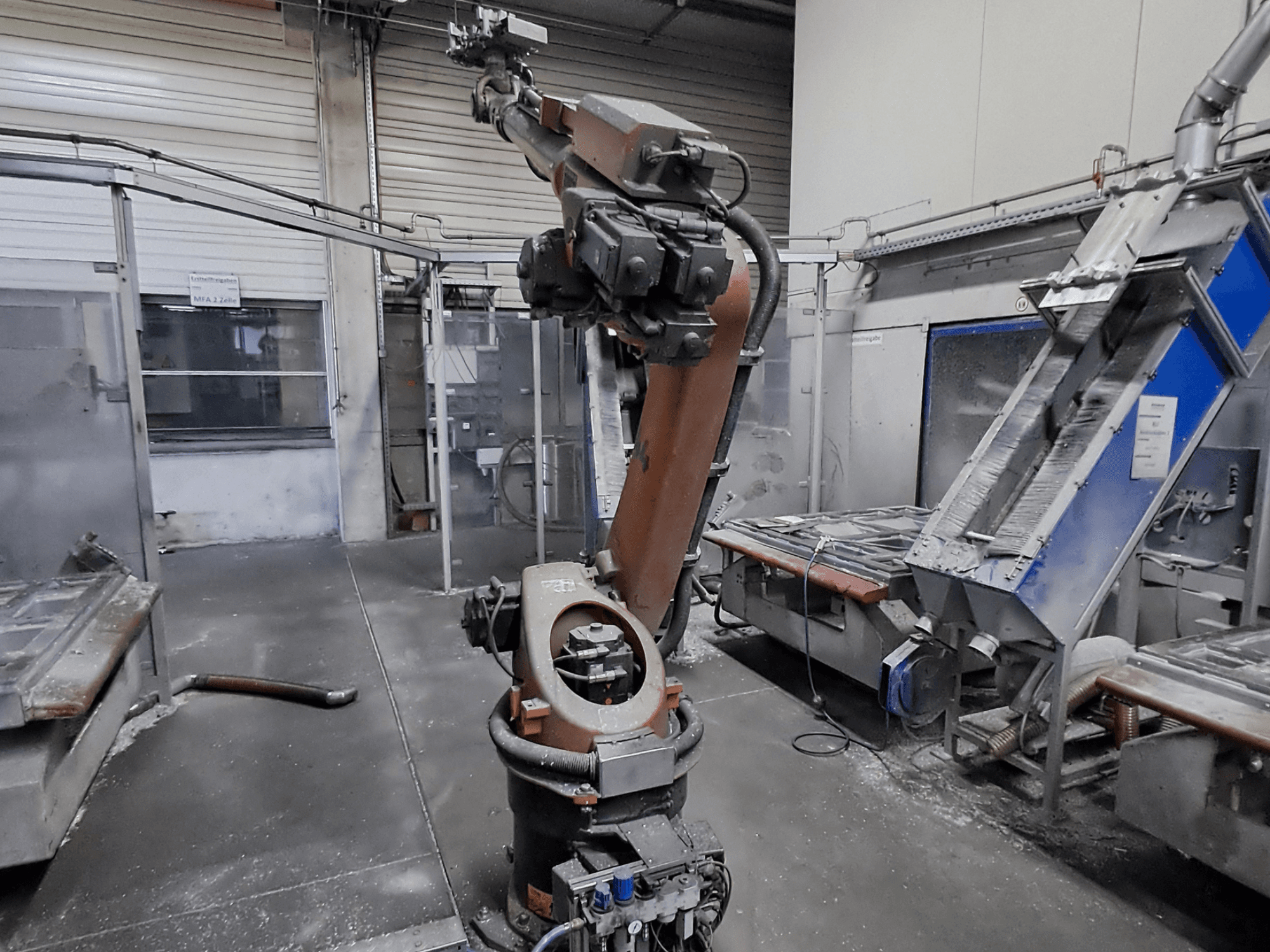 Манипулятор робота KUKA KR 30L16-2 в условиях цеха, вид спереди, на заднем плане видны пыль и оборудование.