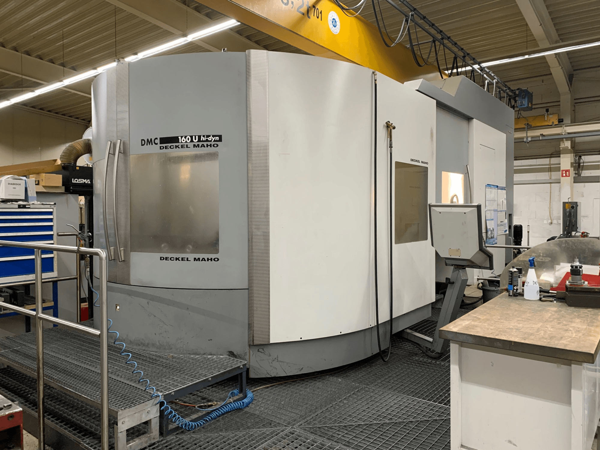 Универсальный обрабатывающий центр DECKEL MAHO DMC 160 U Hi-Dyn, вид спереди, на котором видны панель управления и крупногабаритная конструкция круглой формы.