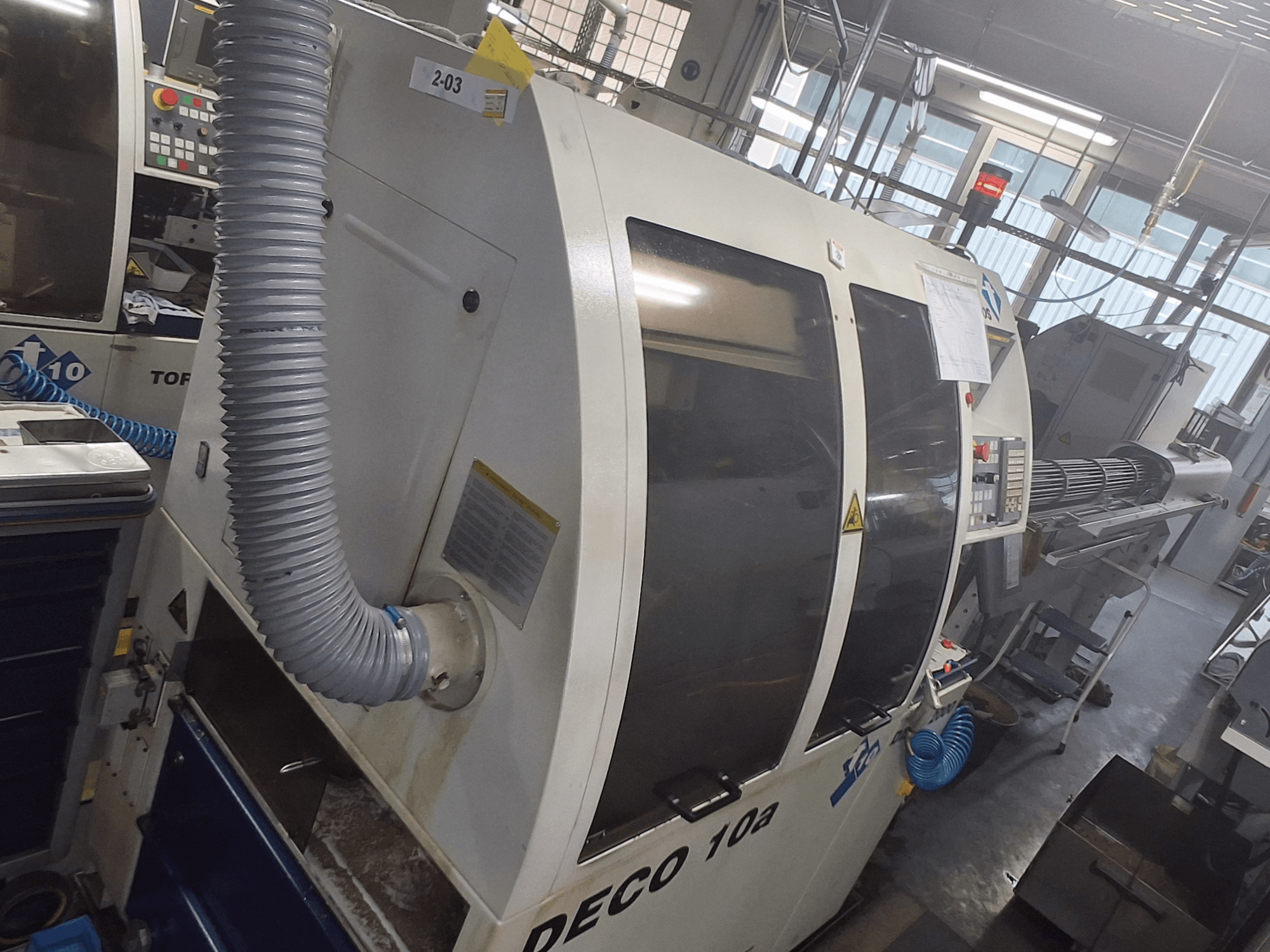 Машина DECO 10a на виде спереди; видна большая панель управления, воздуховоды и рабочие наклейки.