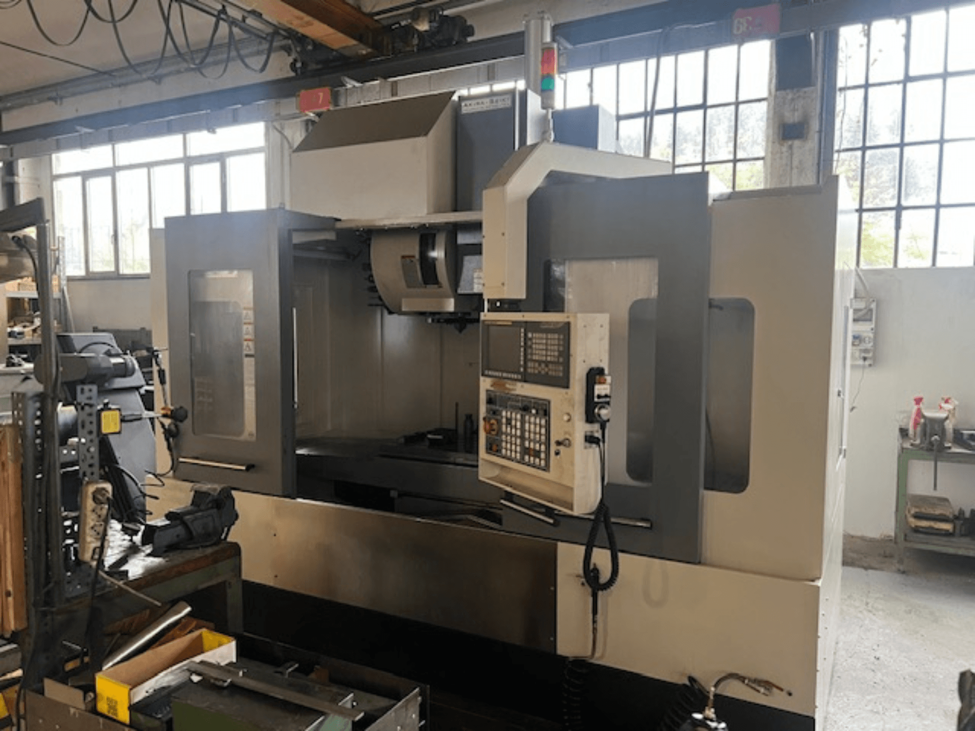 Высокотехнологичный фрезерный станок с ЧПУ, вид спереди, с цифровым управлением, основными индикаторами безопасности и компактным дизайном.