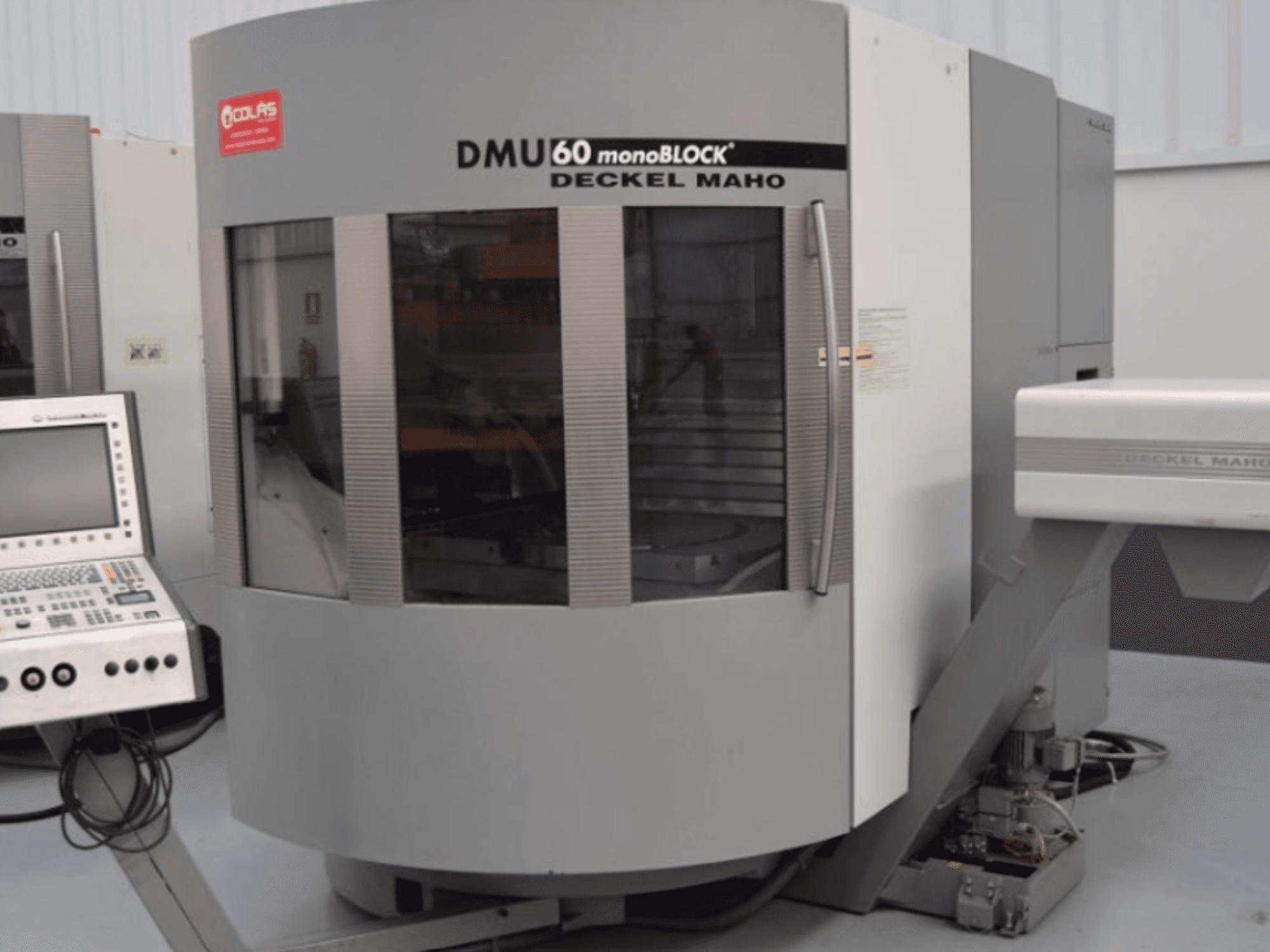 Вертикальный обрабатывающий центр DMG DMU60 Monoblock, вид спереди с панелью управления, видимой слева.