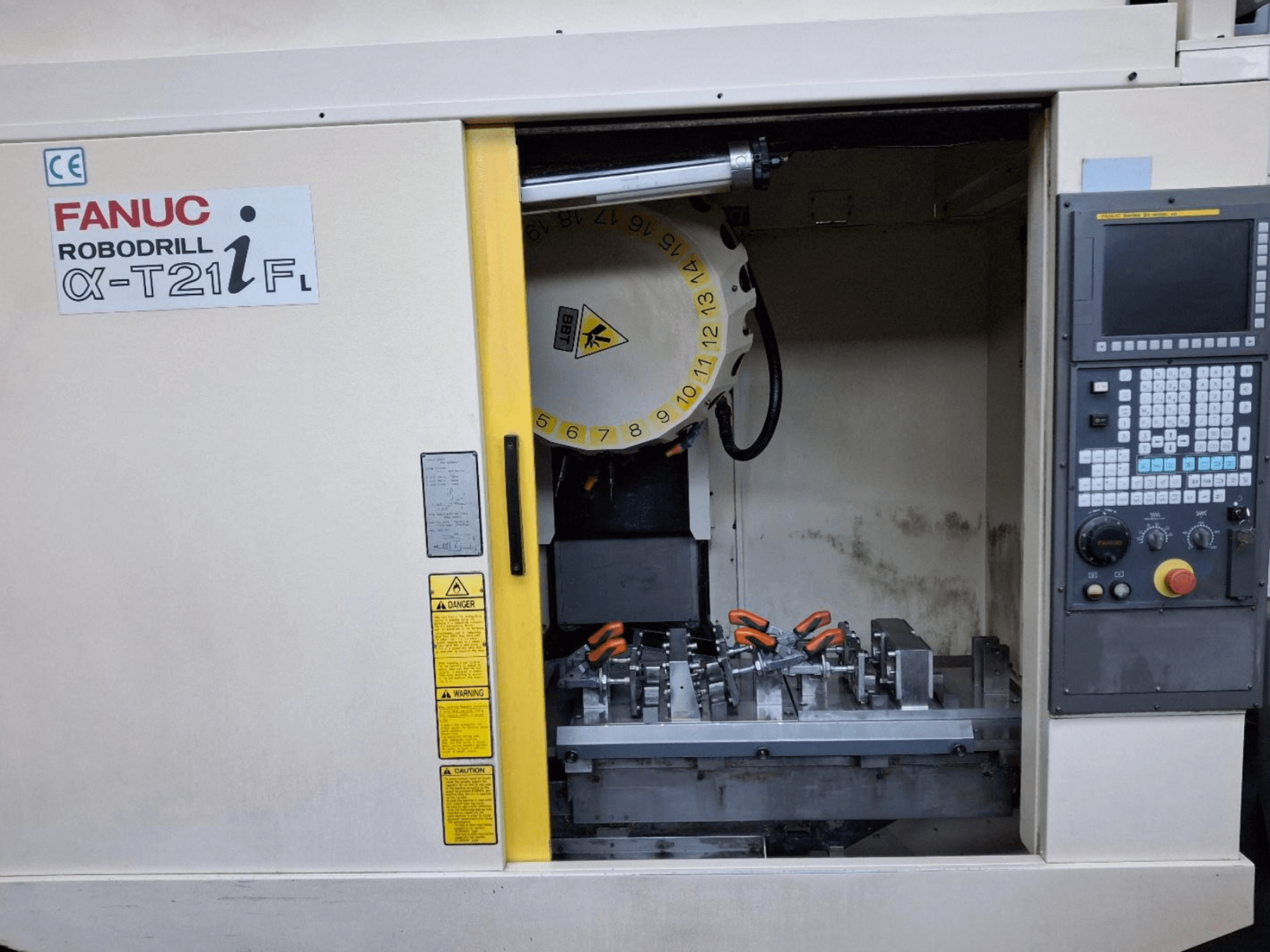 Вертикальный обрабатывающий центр FANUC ROBODRILL α-T21iFL вид спереди, инструменты и органы управления внутри корпуса станка.