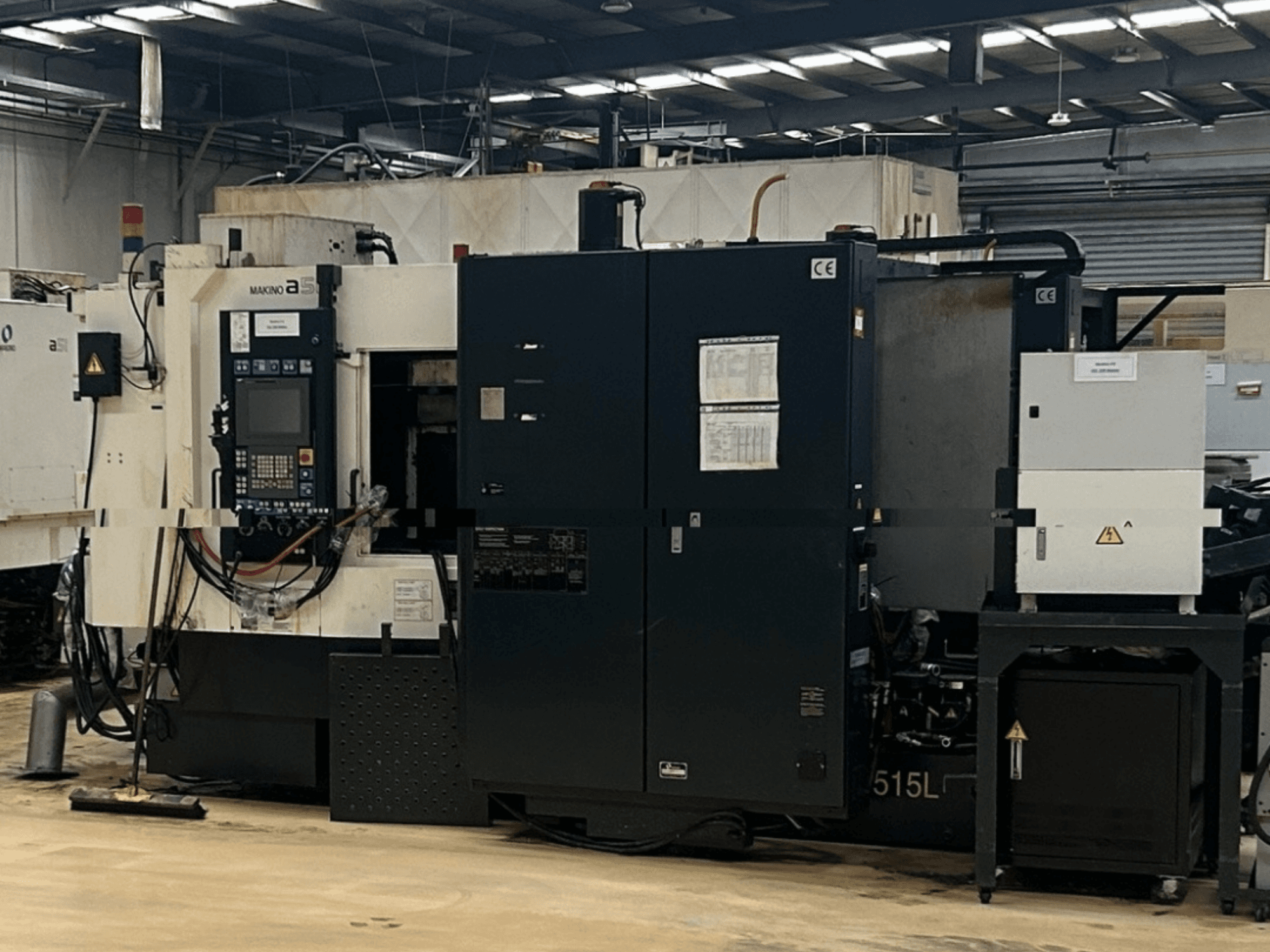 Горизонтальный обрабатывающий центр Makino A51-5XR, вид спереди с панелью управления, блоком питания и узлами станка.