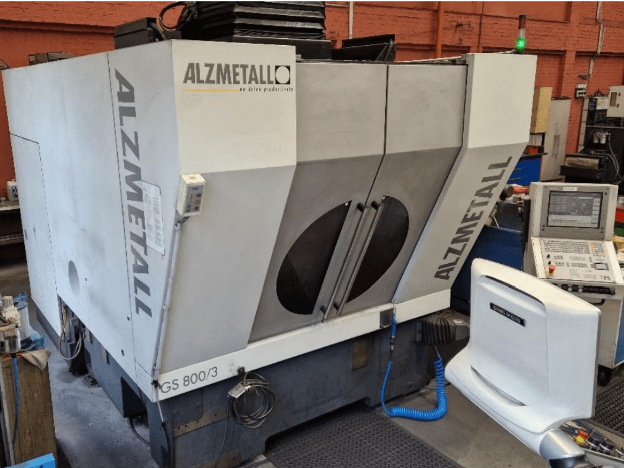 Вертикальный обрабатывающий центр Alzmetall GS 800/3, вид спереди, на котором видны корпус станка и панель управления.