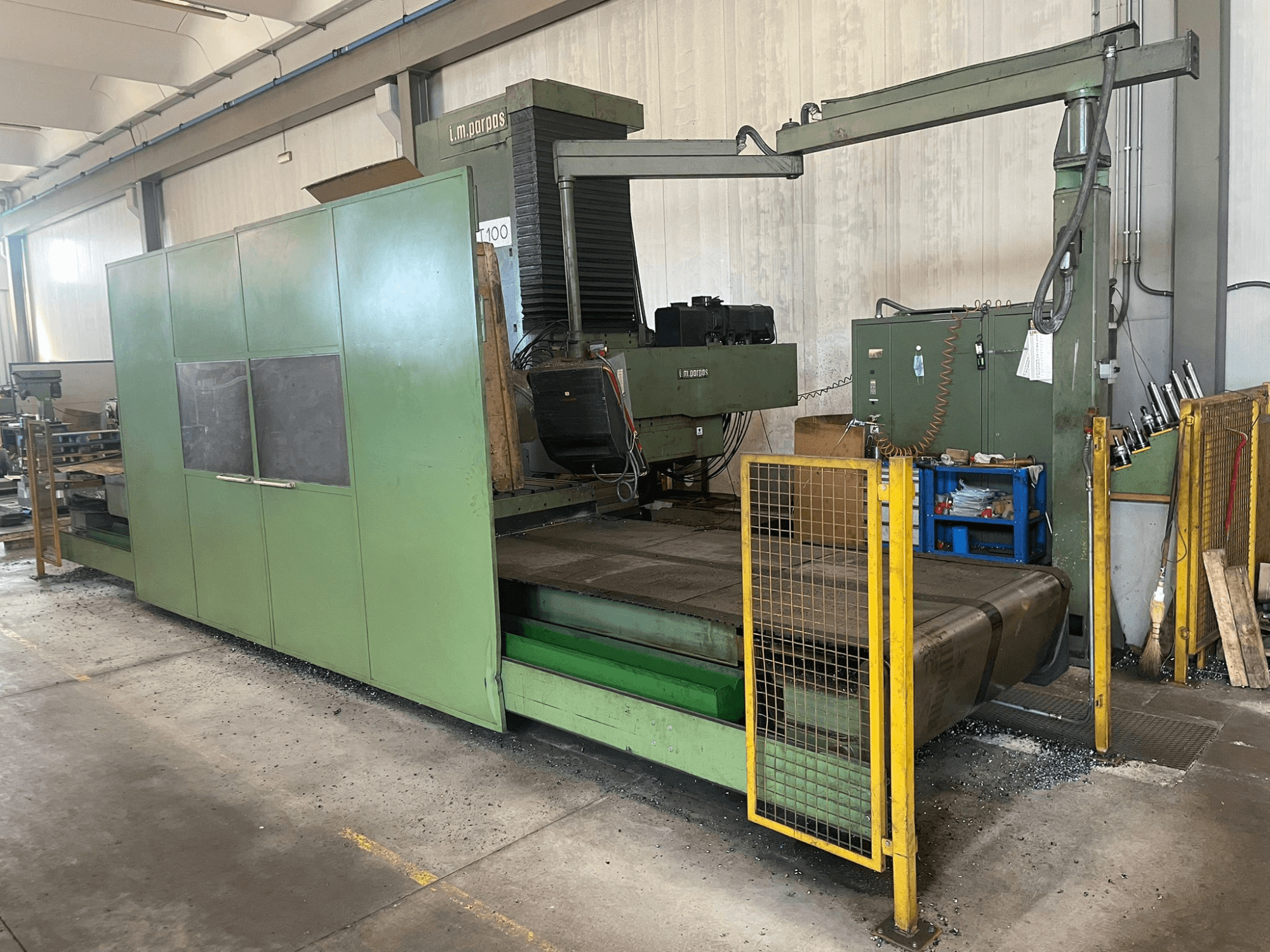 Большой зеленый промышленный фрезерный станок с защитными ограждениями, вид спереди, наклейка с моделью "l.m. parpas" и видимые элементы управления.