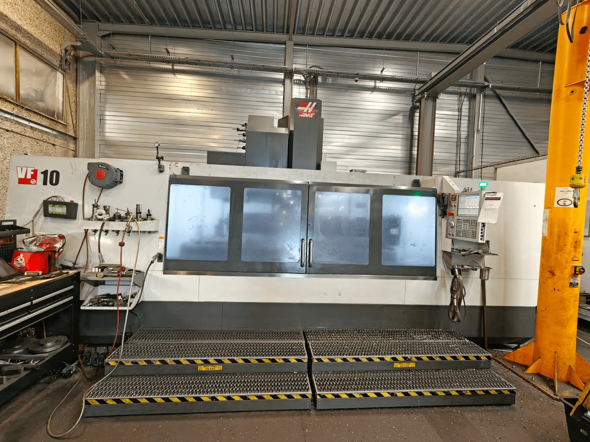 Вертикальный обрабатывающий центр HAAS VF-10/50, вид спереди, с панелью управления и большими смотровыми окнами.
