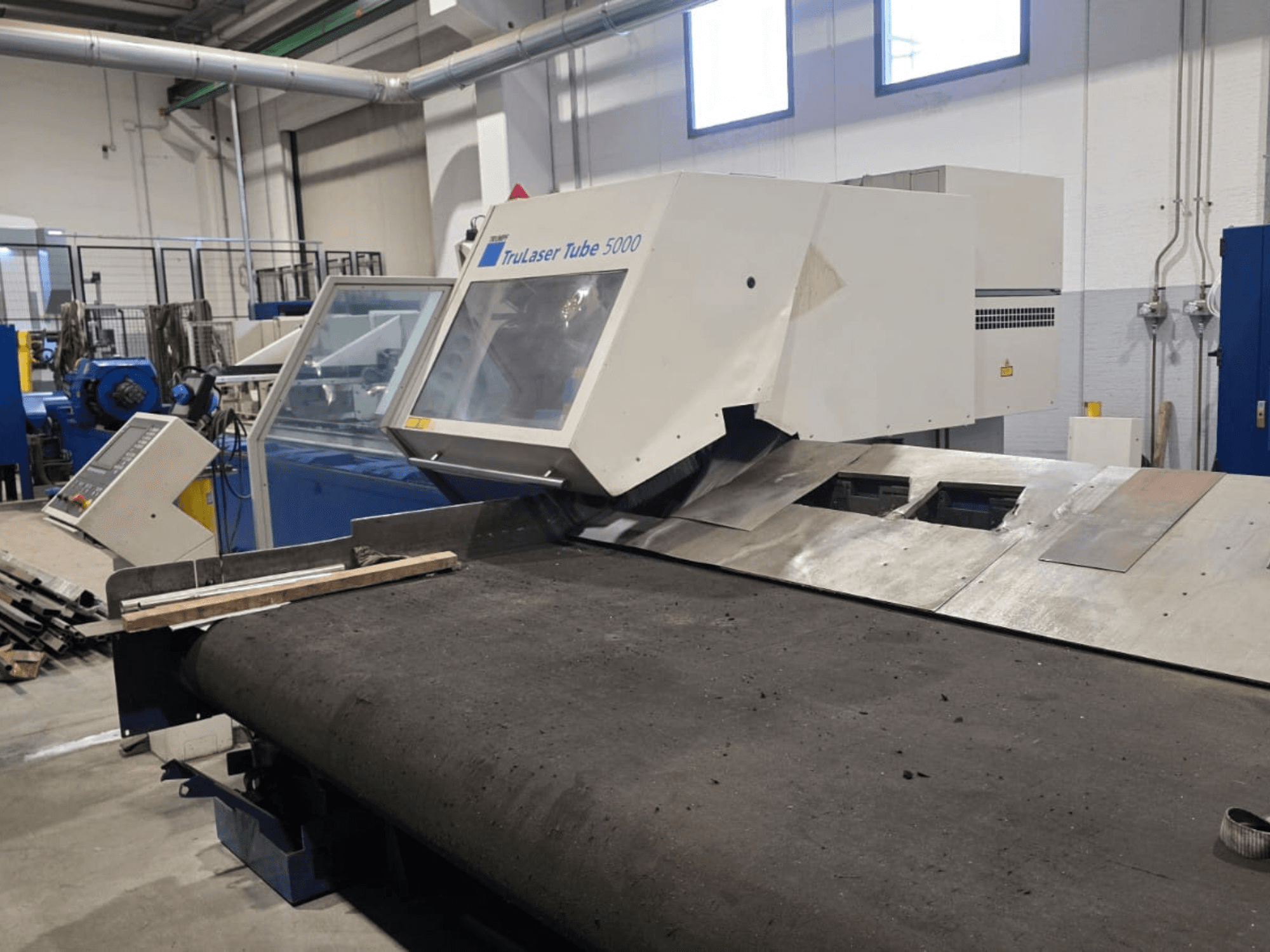 Станок для резки труб TRUMPF LASERTUBE 5000, вид спереди, на котором видны зона резки и панель управления.