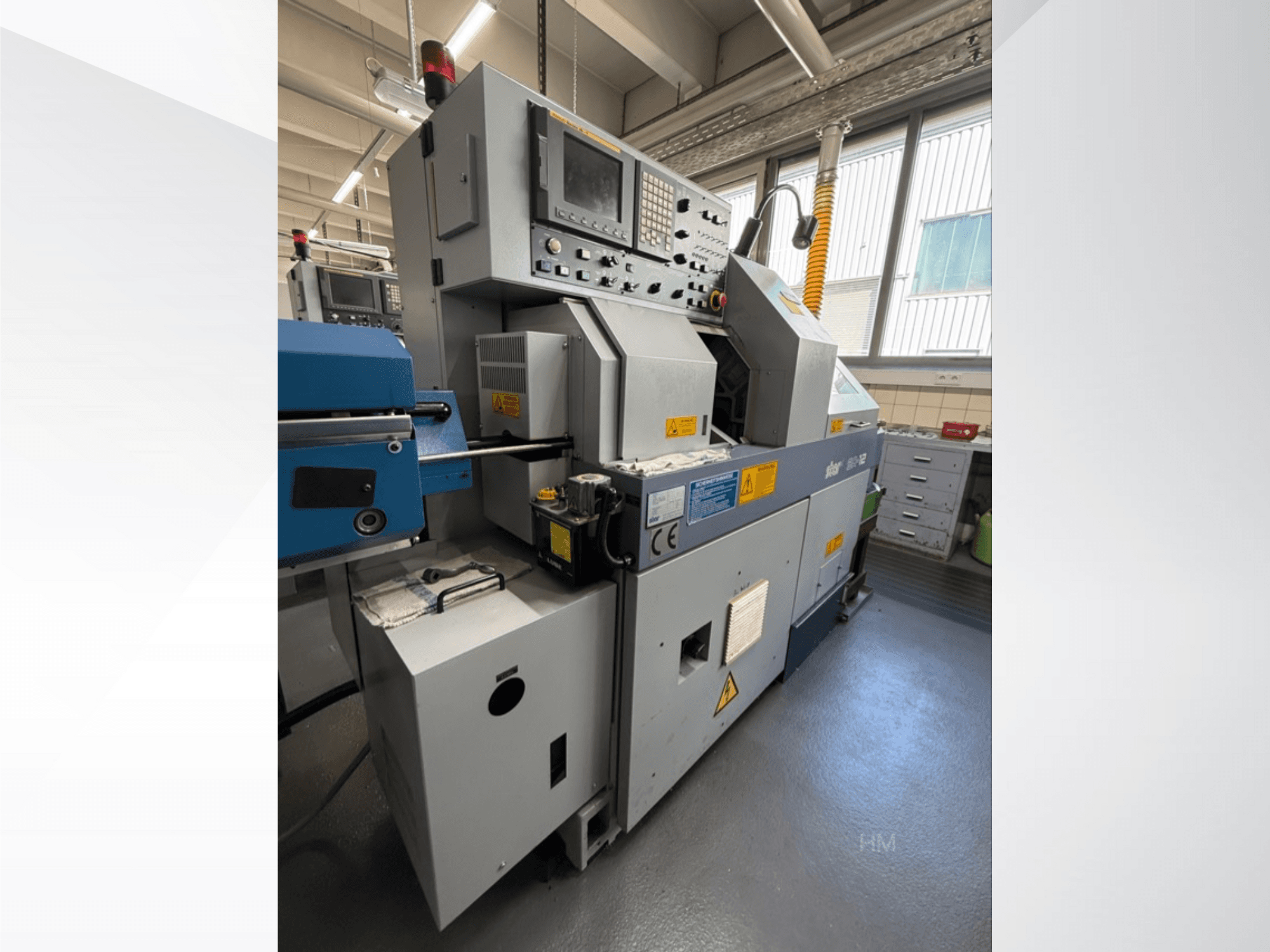 Вид спереди машины lithec 3231 с панелью управления, двигателем и синей подающей секцией в хорошо освещенном промышленном помещении.