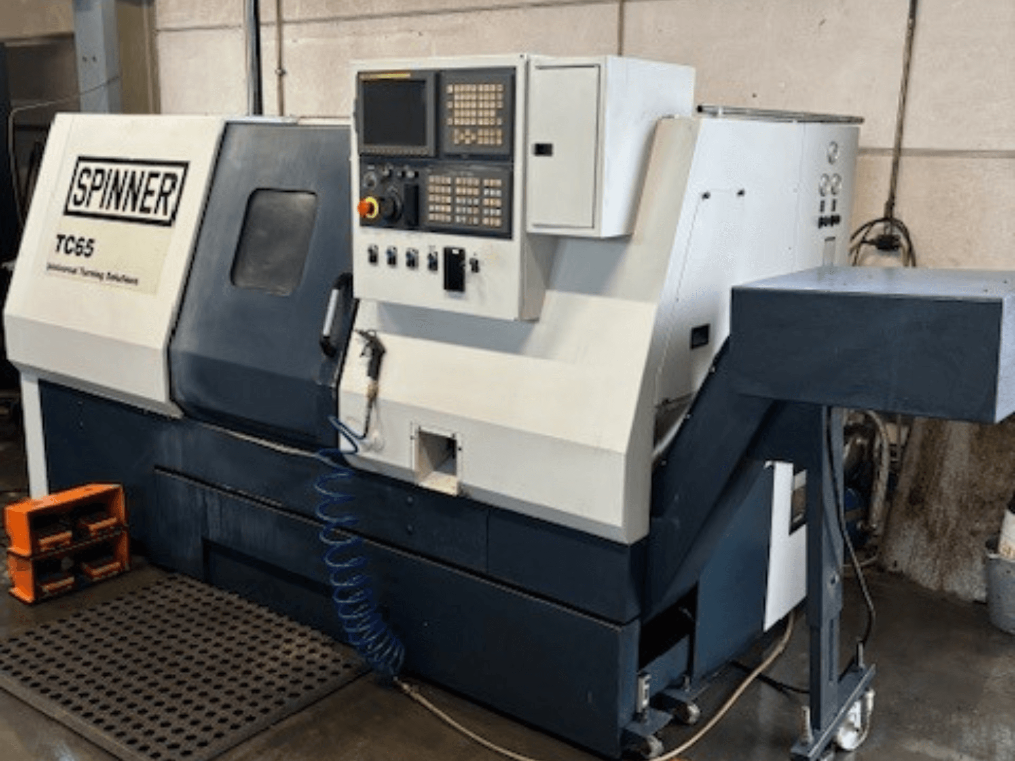 Промышленный токарный станок Spinner TC65, вид спереди, панель управления, линия подачи сжатого воздуха и место для хранения инструментов.